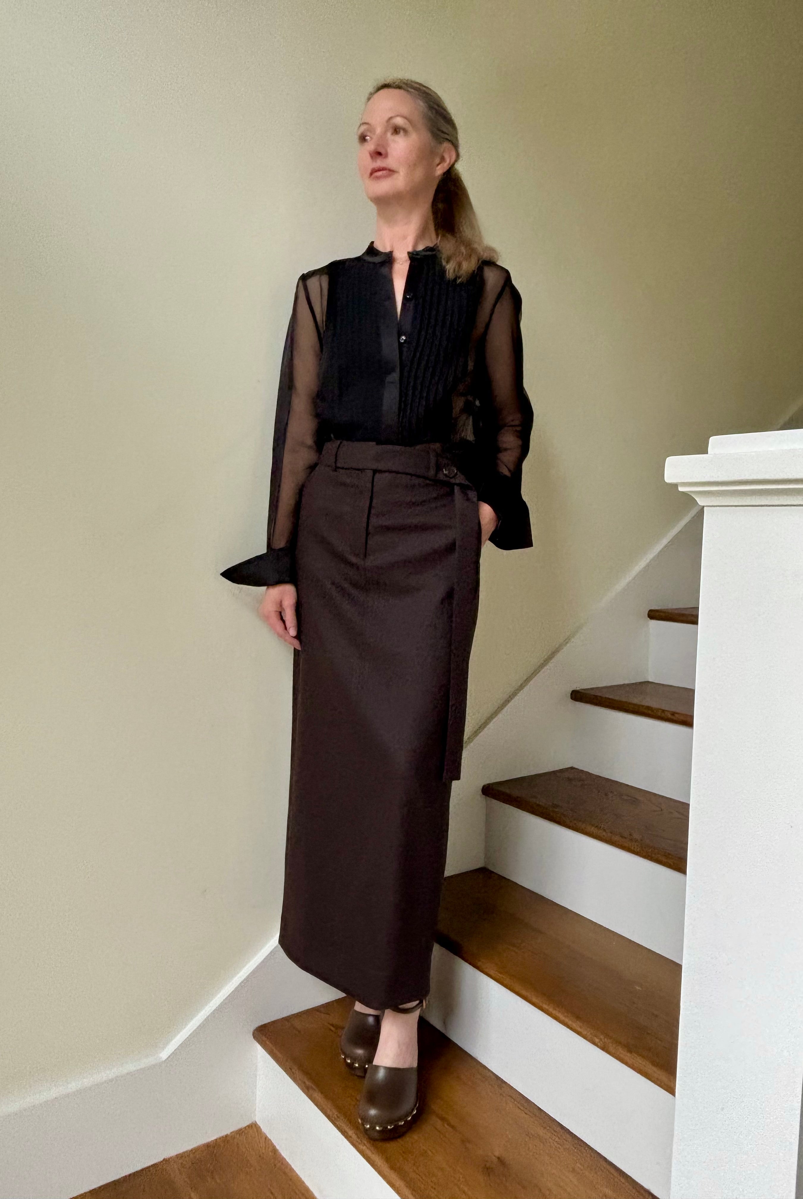 Image of mature woman wearing luxury brand TWP Peyton blouse with a pleated tuxedo front, long sleeve and sophisticated sheer silk fabric
