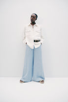 Model wearing luxury brand TWP Demie High Rise wide leg indigo hemp Pants offers timeless  refinement and expert craftsmanship