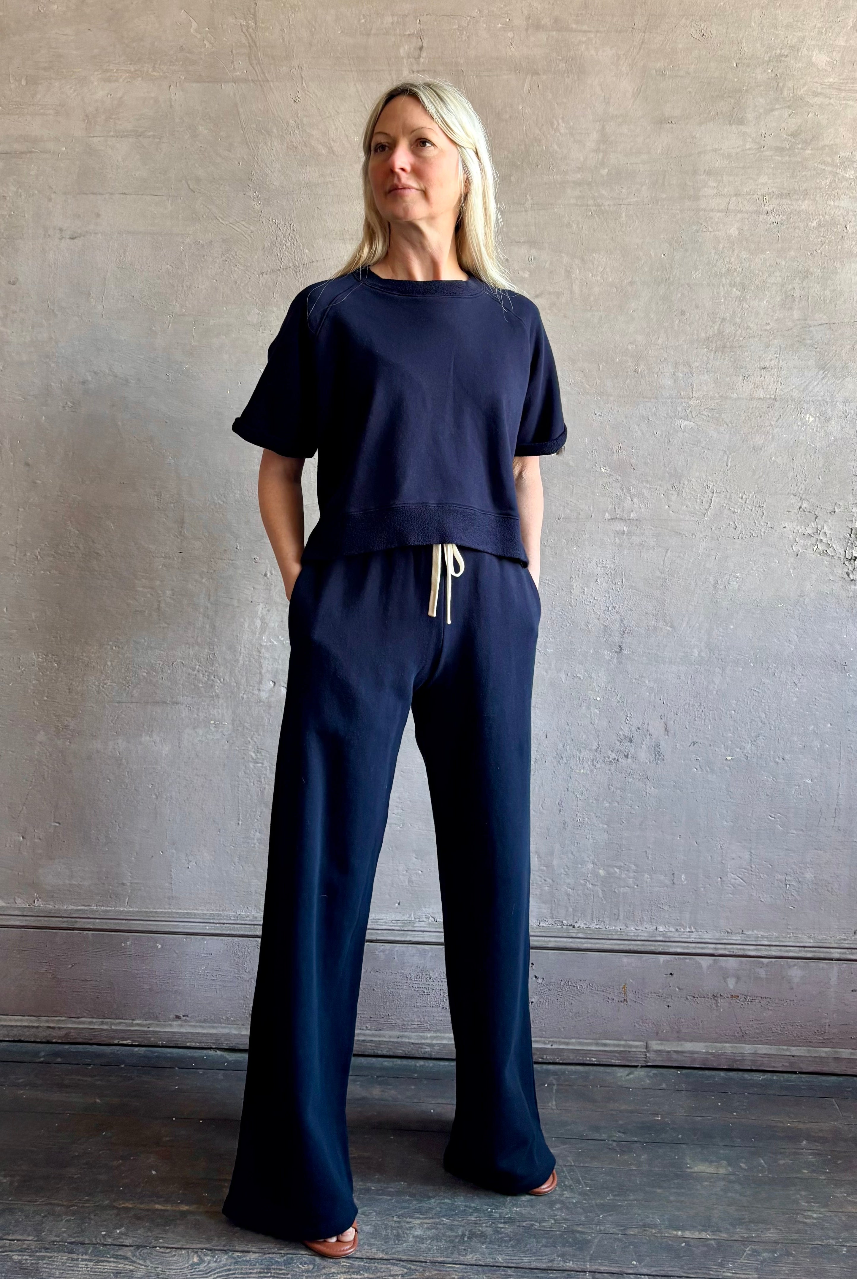 Mature woman wearing the PJ Pant from TWP is a luxuriously relaxed women's designer lounge pant crafted from cotton with a straight leg and effortless pull-on waist