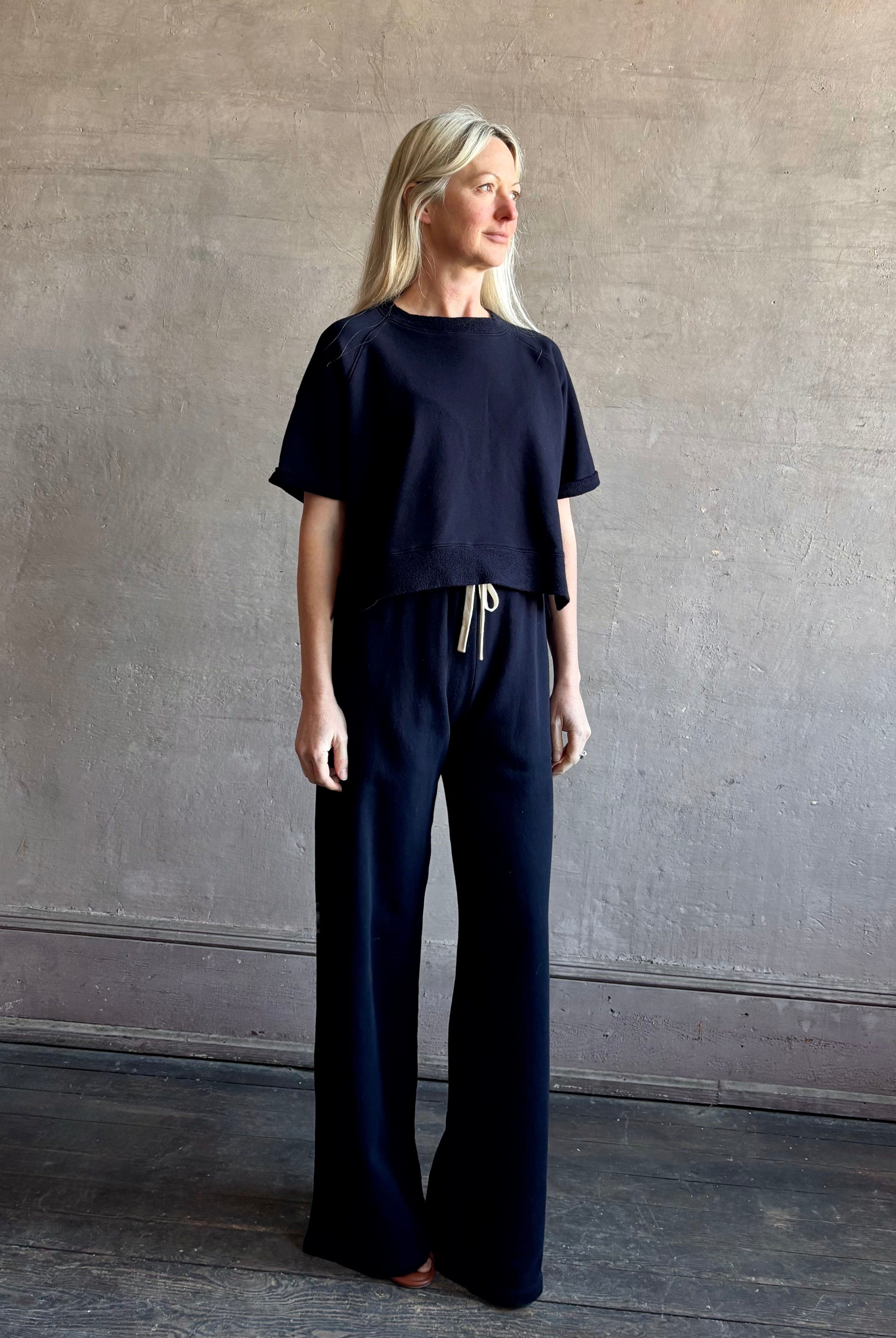 Mature woman wearing the PJ Pant from TWP is a luxuriously relaxed women's designer lounge pant crafted from cotton with a straight leg and effortless pull-on waist