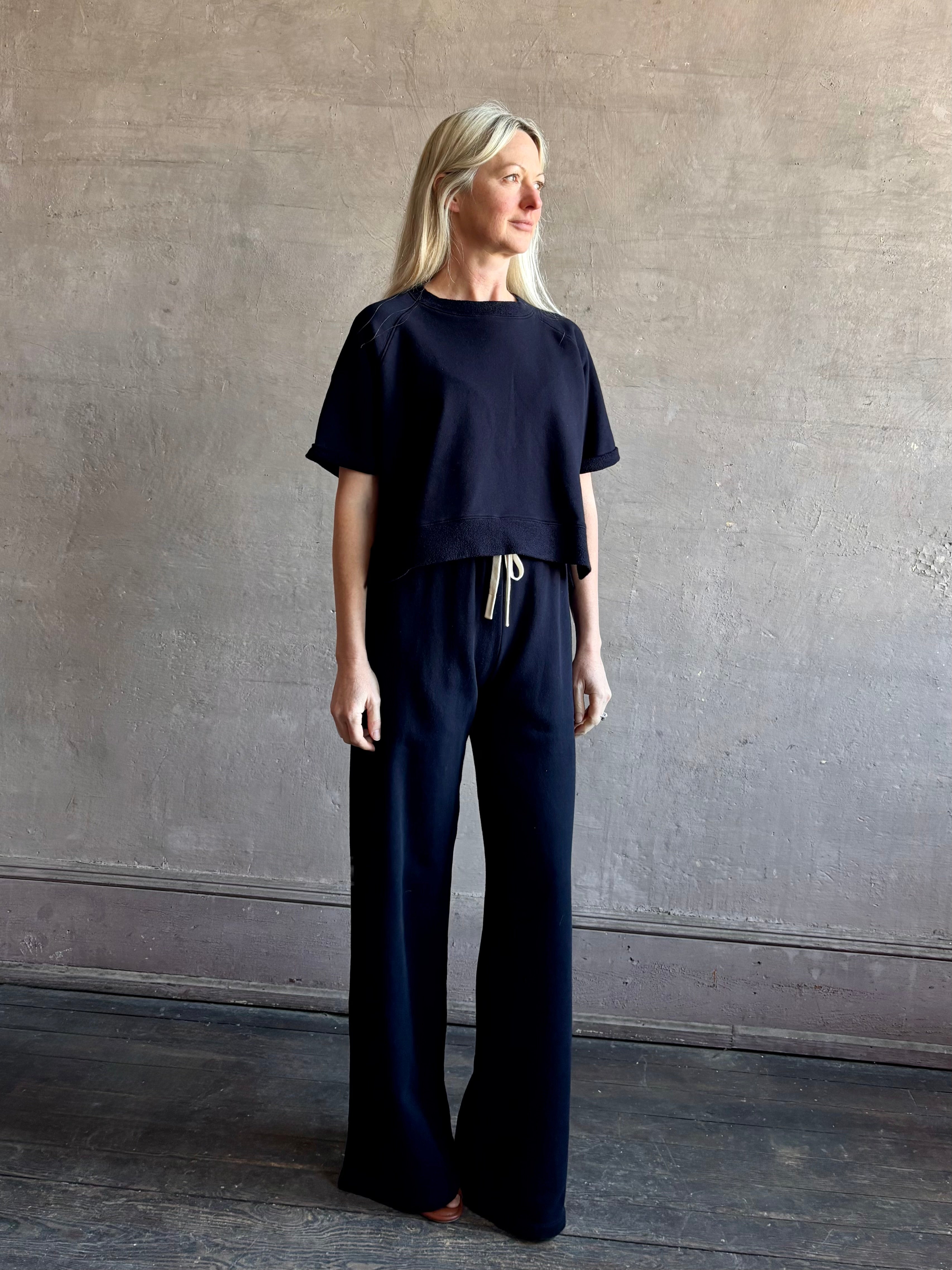 Mature woman wearing the PJ Pant from TWP is a luxuriously relaxed women's designer lounge pant crafted from cotton with a straight leg and effortless pull-on waist
