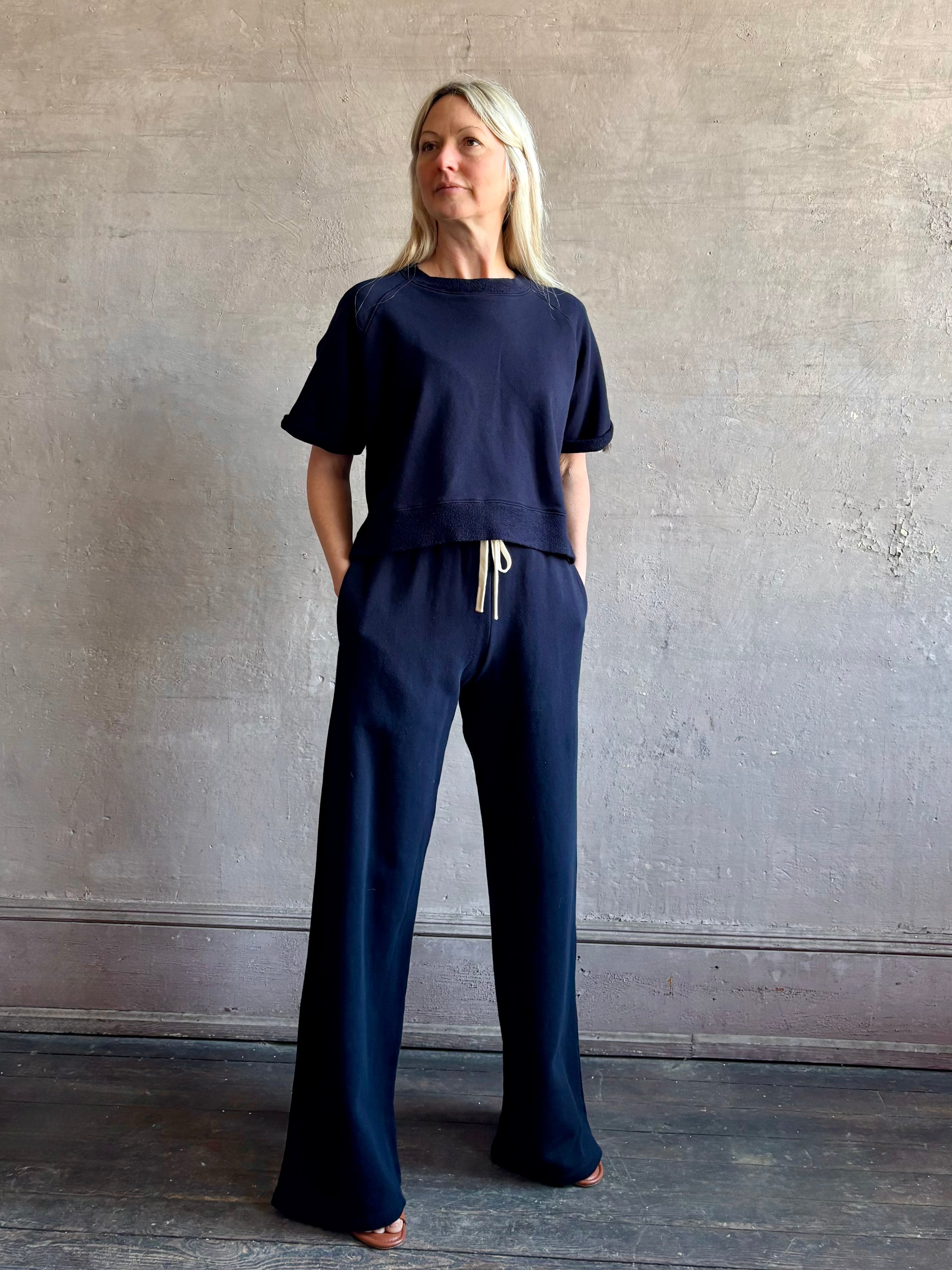 Mature woman wearing the PJ Pant from TWP is a luxuriously relaxed women's designer lounge pant crafted from cotton with a straight leg and effortless pull-on waist