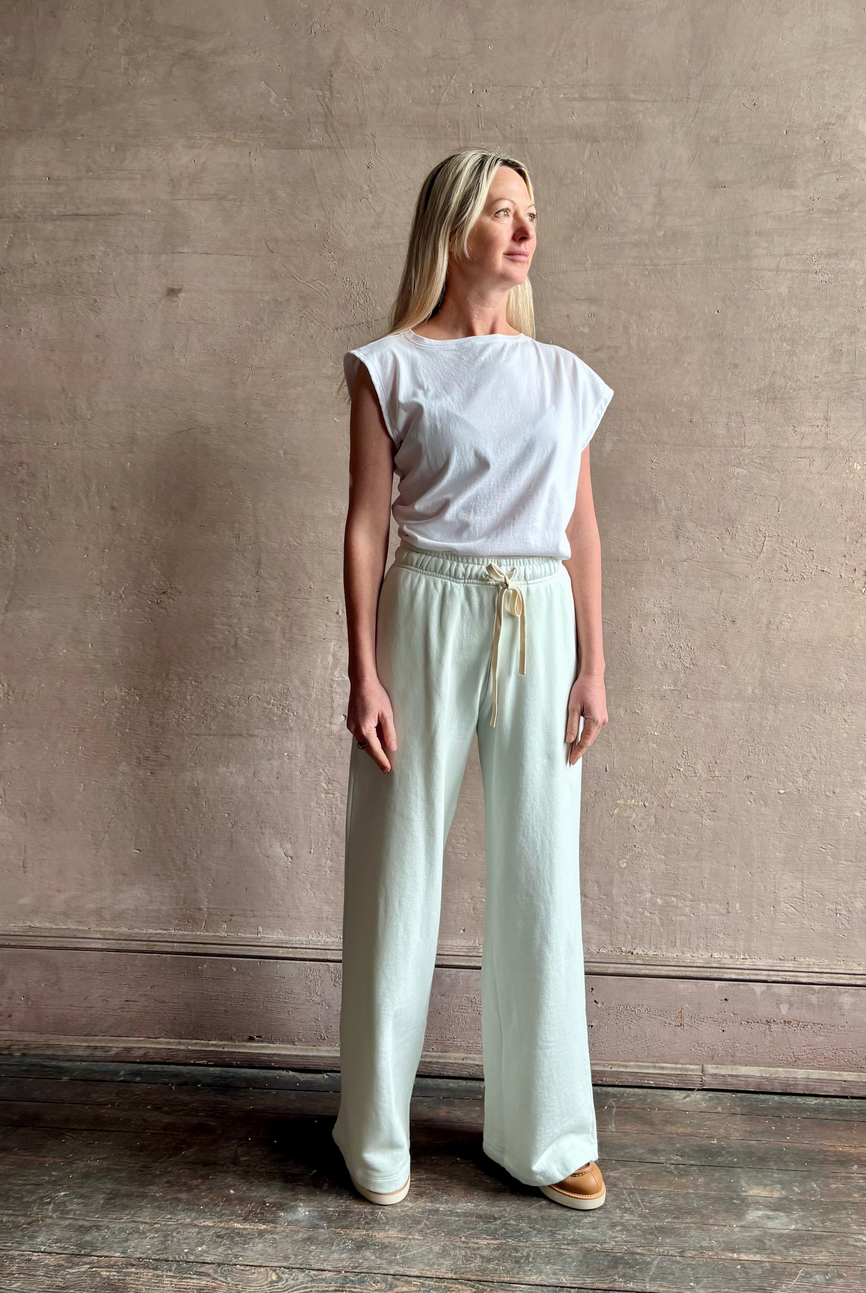 Mature woman wearing the PJ Pant from TWP is a luxuriously relaxed women's designer lounge pant crafted from cotton with a straight leg and effortless pull-on waist