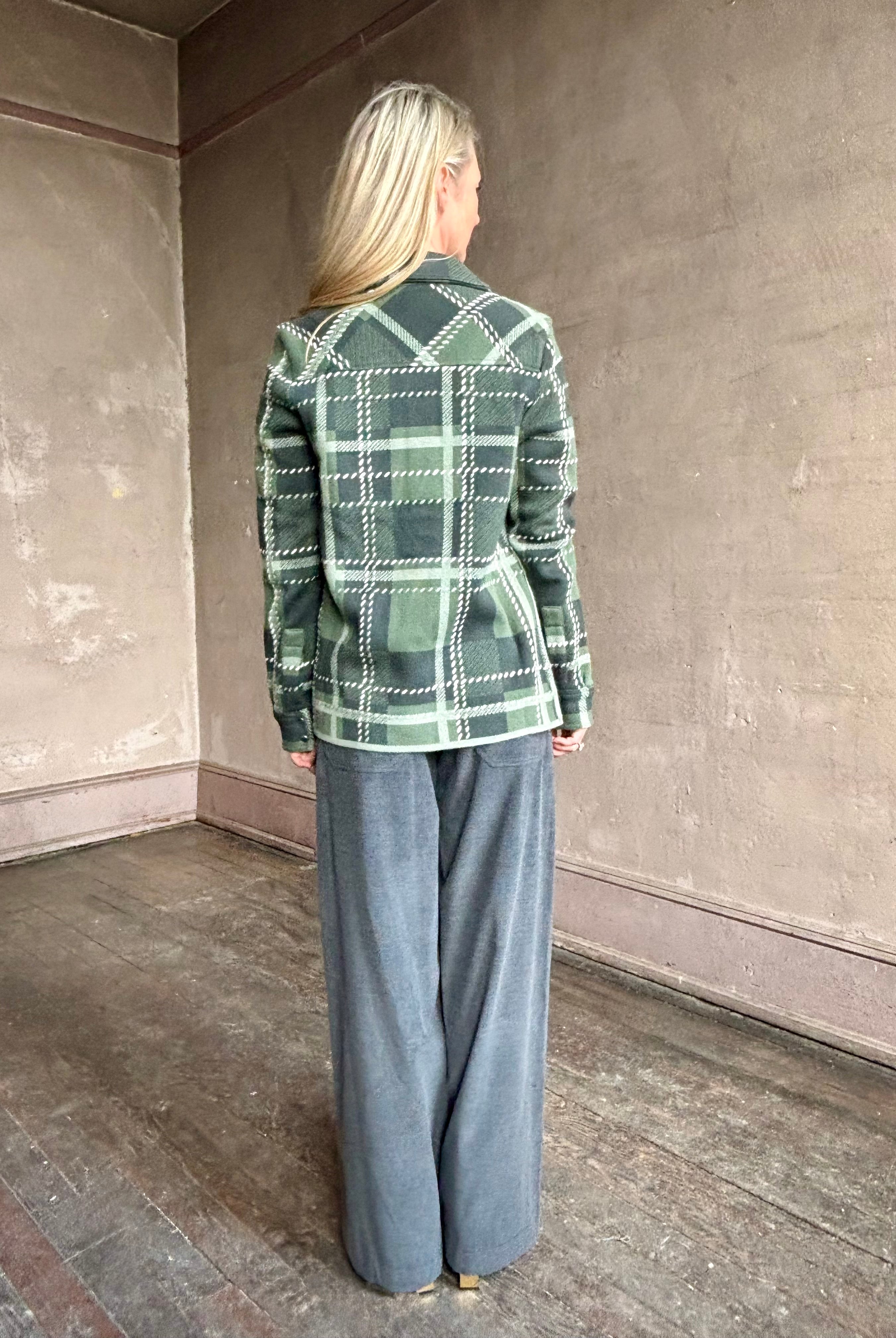 Image of mature woman wearing TWP ranchers cardigan fabricated with premium cashmere in classic green plaid