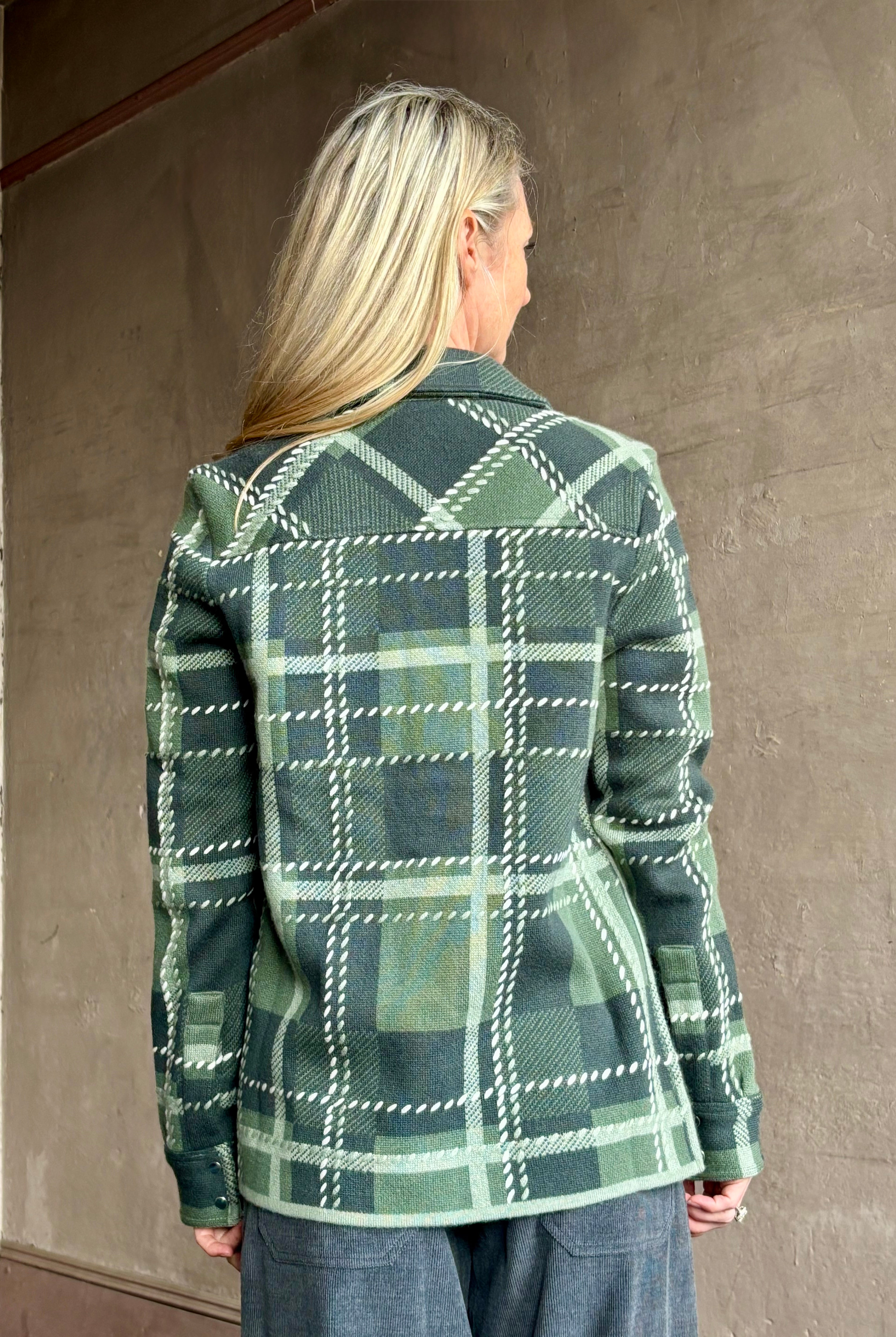 Image of mature woman wearing mountain-inspired comfort TWP ranchers cardigan in classic green plaid perfect for layering