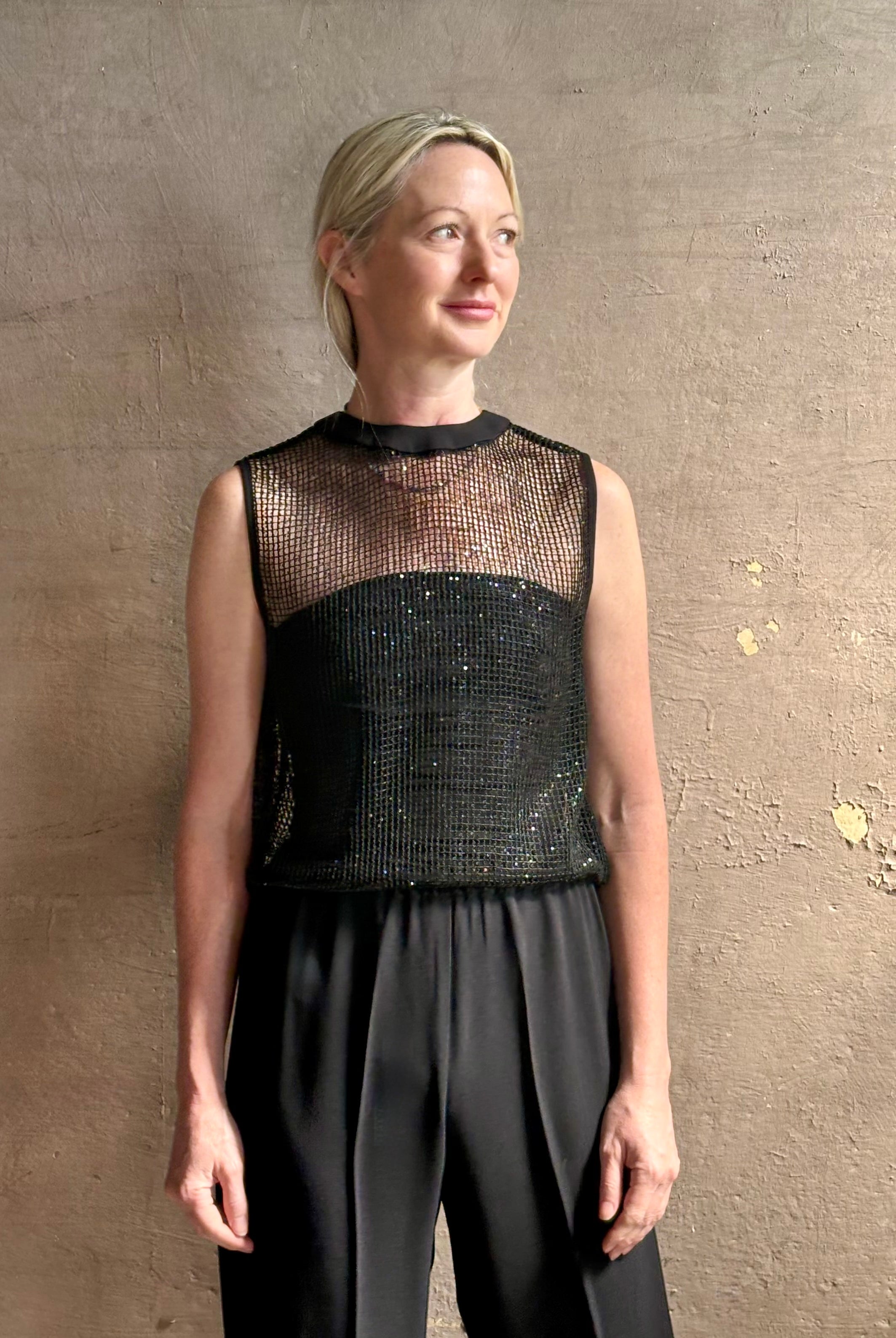 Image of mature woman wearing Women's designer clothing label TWP short muscle tank in black with subtle sequin embellishments perfect for luxury layering