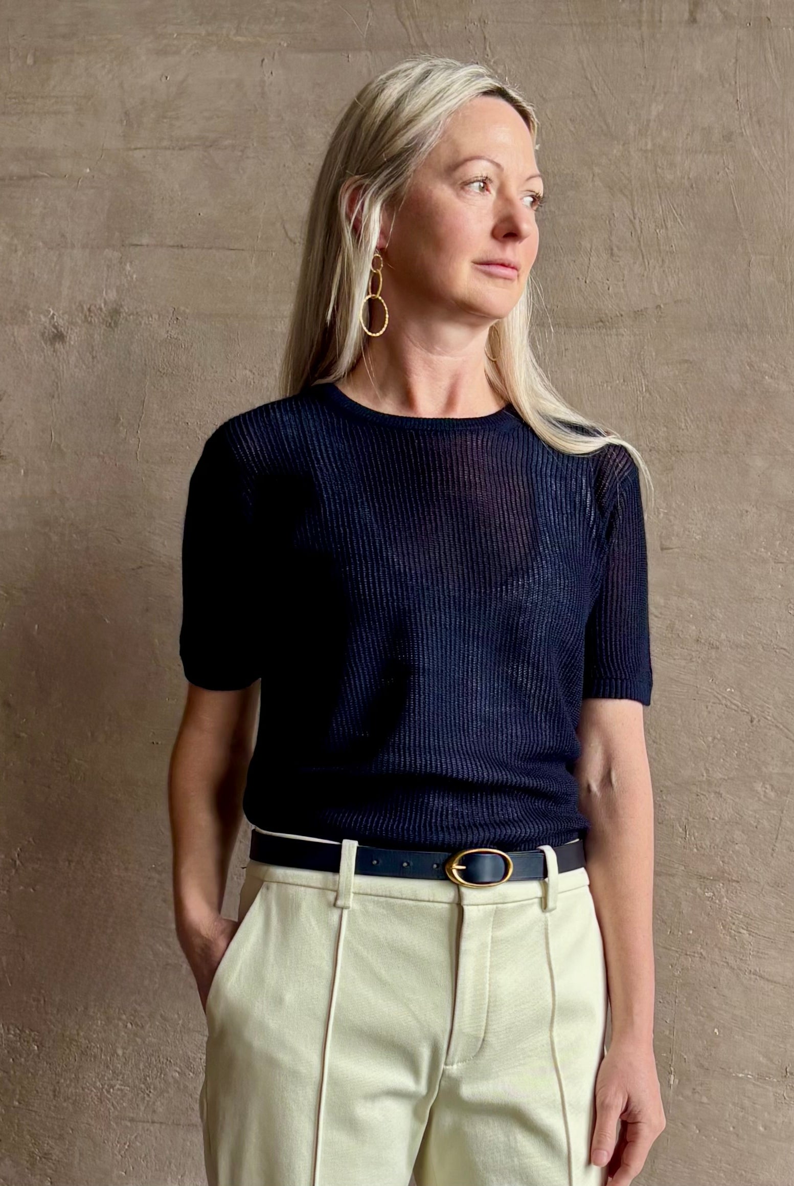 Mature woman wearing luxury Short Sleeve navy blue cashmere Tee Sweater from TWP with open weave and crew neck