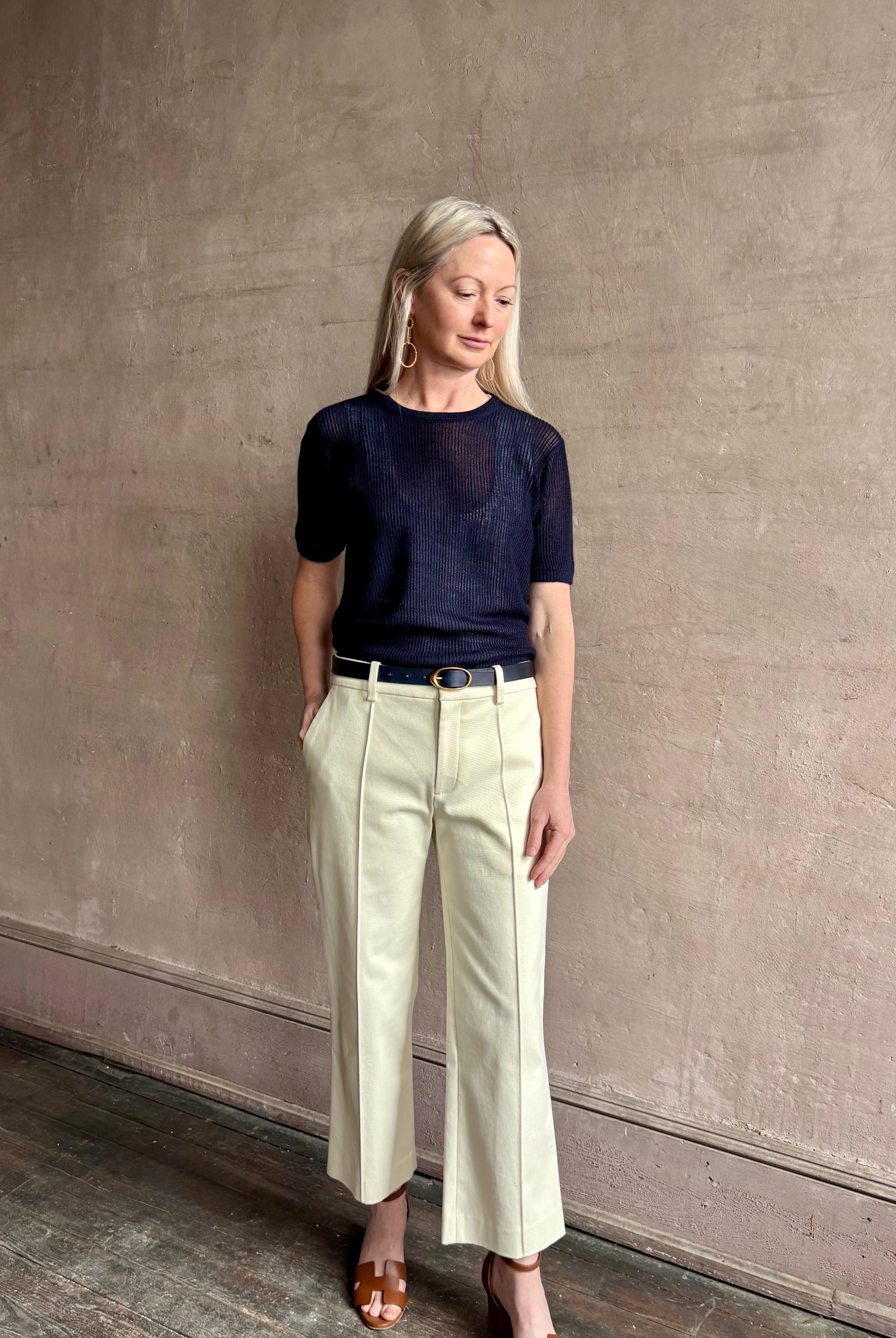 Mature woman wearing luxury Short Sleeve navy blue cashmere Tee Sweater from TWP with open weave and crew neck