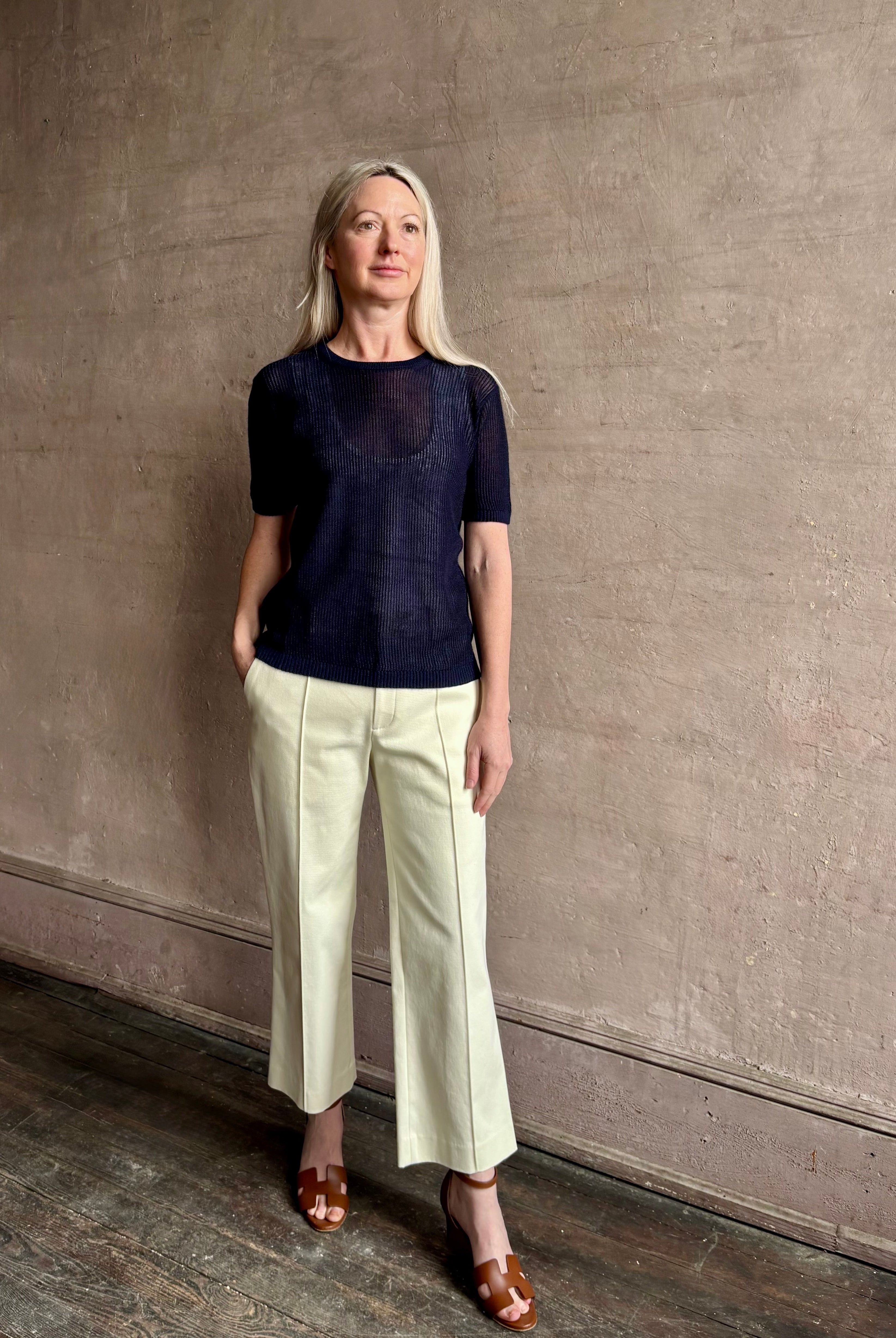 Mature woman wearing luxury Short Sleeve navy blue cashmere Tee Sweater from TWP with open weave and crew neck