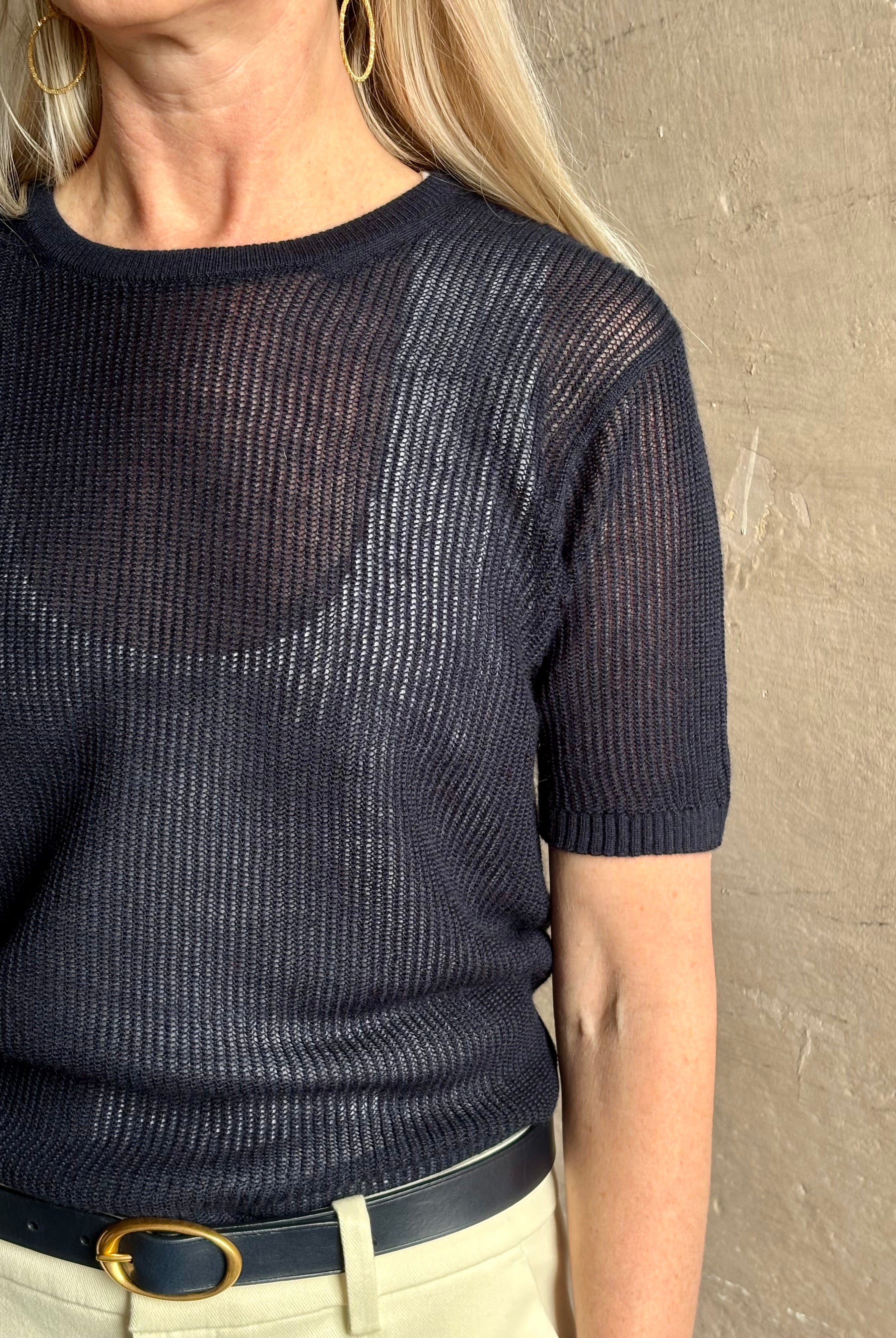 Mature woman wearing luxury Short Sleeve navy blue cashmere Tee Sweater from TWP with lightweight open weave and crew neckline