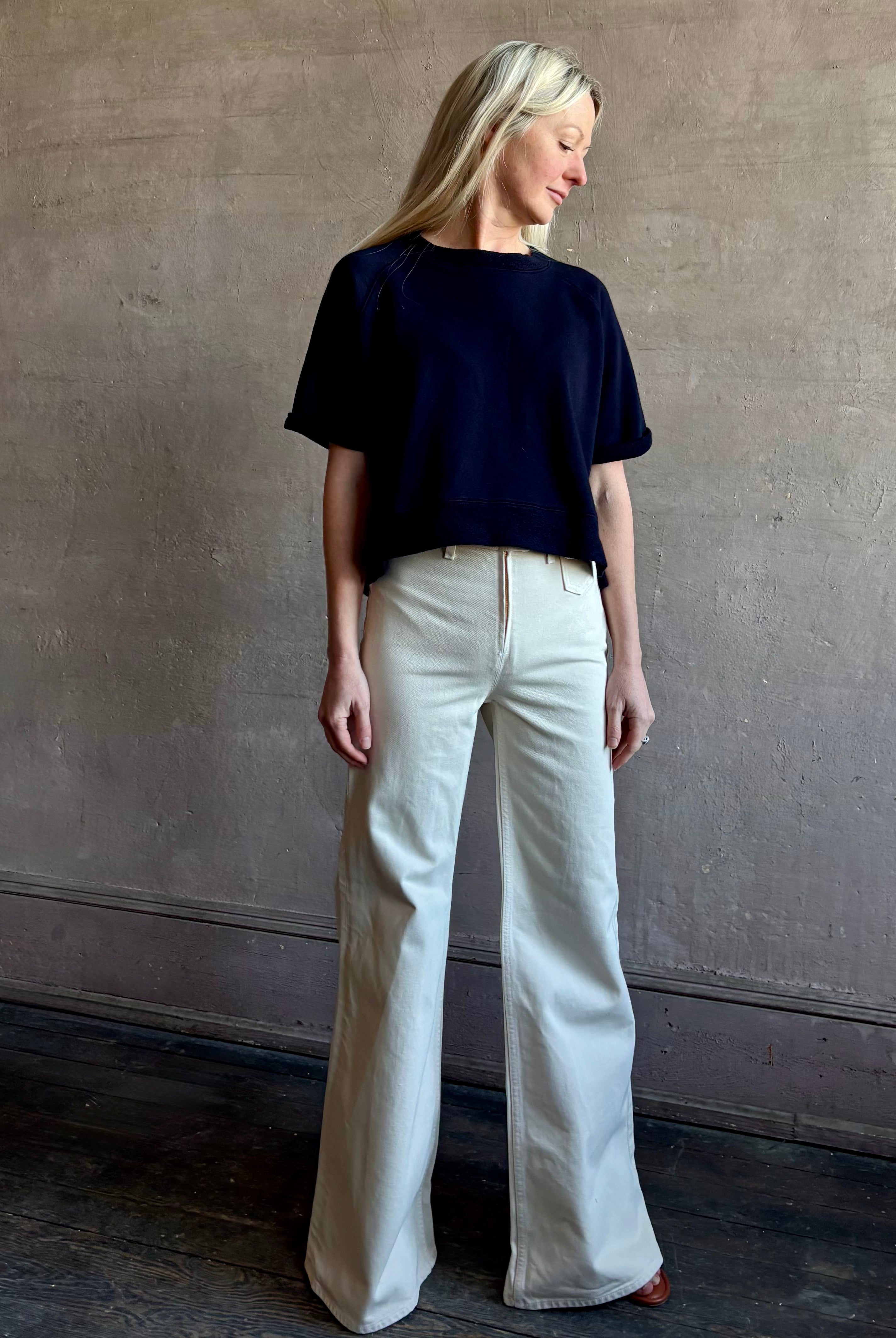 Mature woman waring the Slouchy Rolled Tee Top from TWP luxury women's designer tee rendered in a versatile navy blue and crafted from 100% cotton with short sleeves and crew neckline