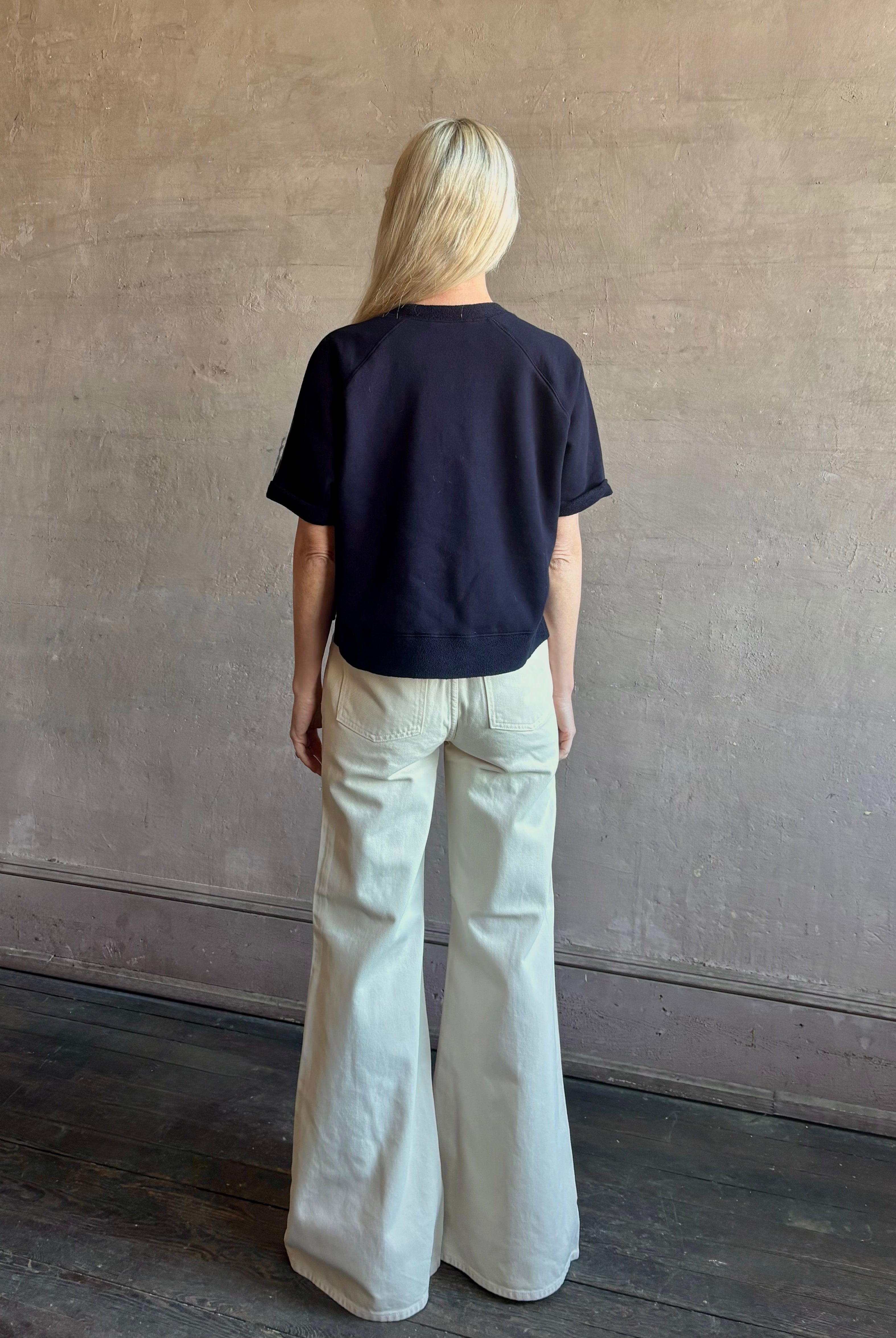 Mature woman waring the Slouchy Rolled Tee Top from TWP luxury women's designer tee rendered in a versatile navy blue and crafted from 100% cotton with short sleeves and crew neckline