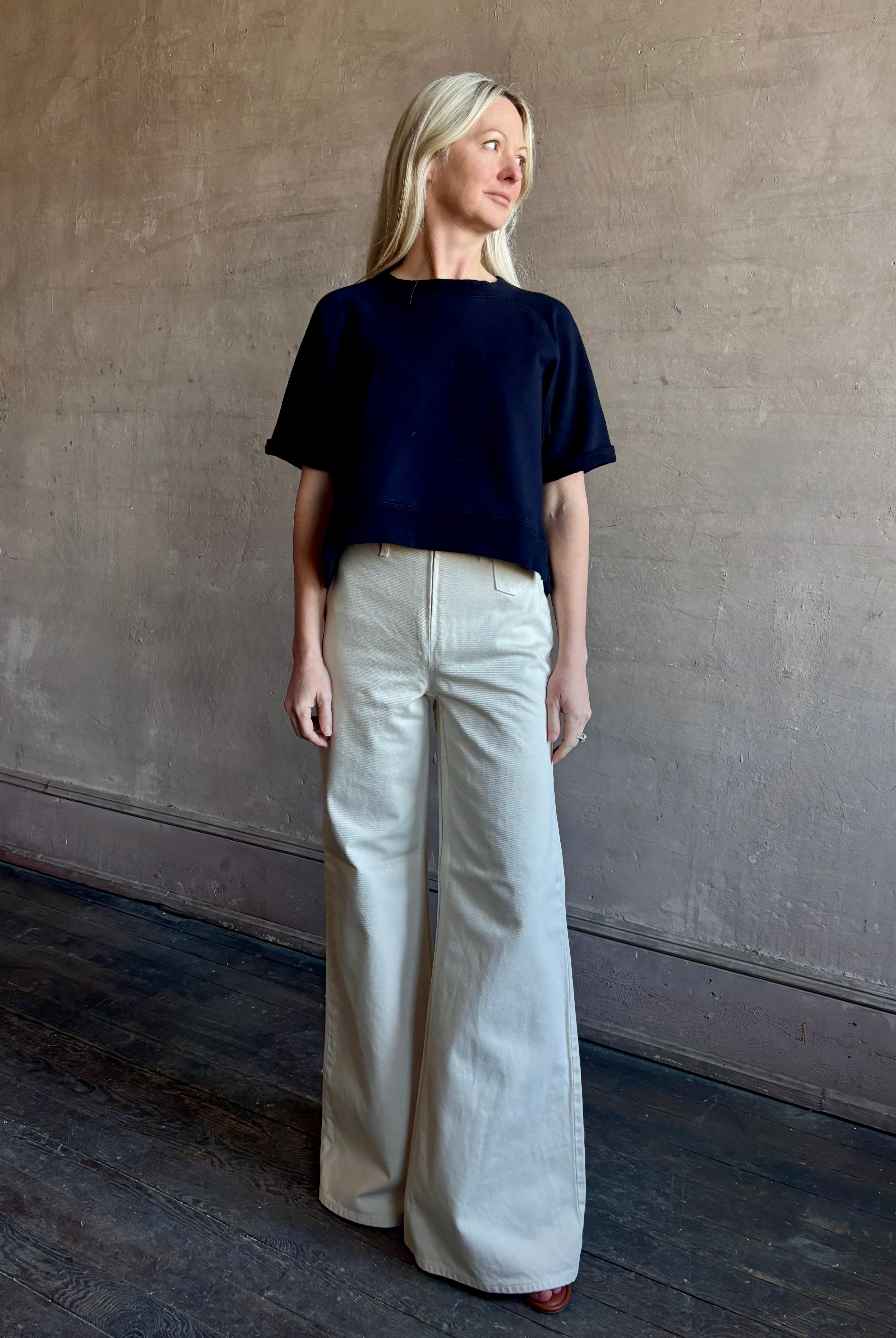 Mature woman waring the Slouchy Rolled Tee Top from TWP luxury women's designer tee rendered in a versatile navy blue and crafted from 100% cotton with short sleeves and crew neckline