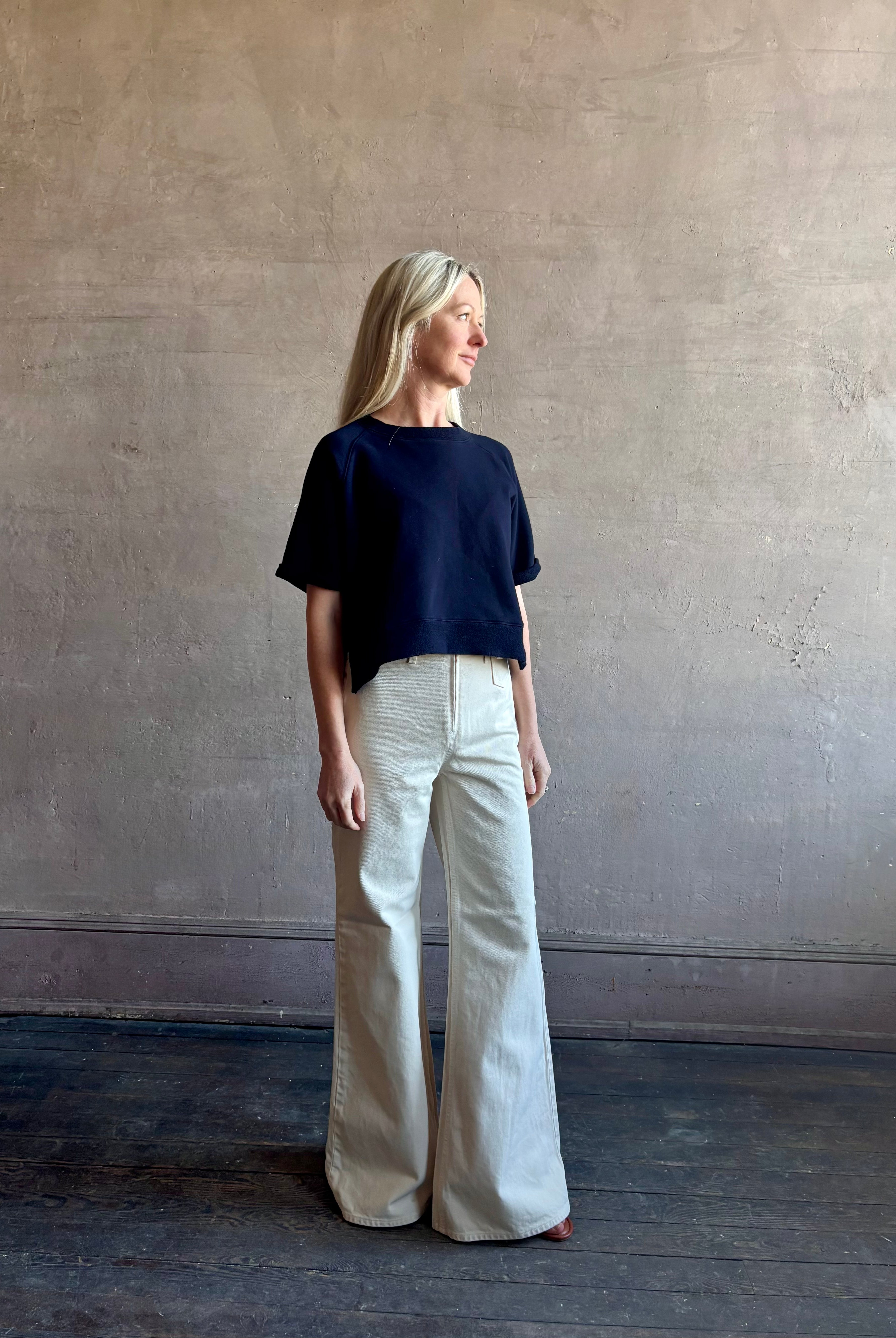 Mature woman waring the Slouchy Rolled Tee Top from TWP luxury women's designer tee rendered in a versatile navy blue and crafted from 100% cotton with short sleeves and crew neckline