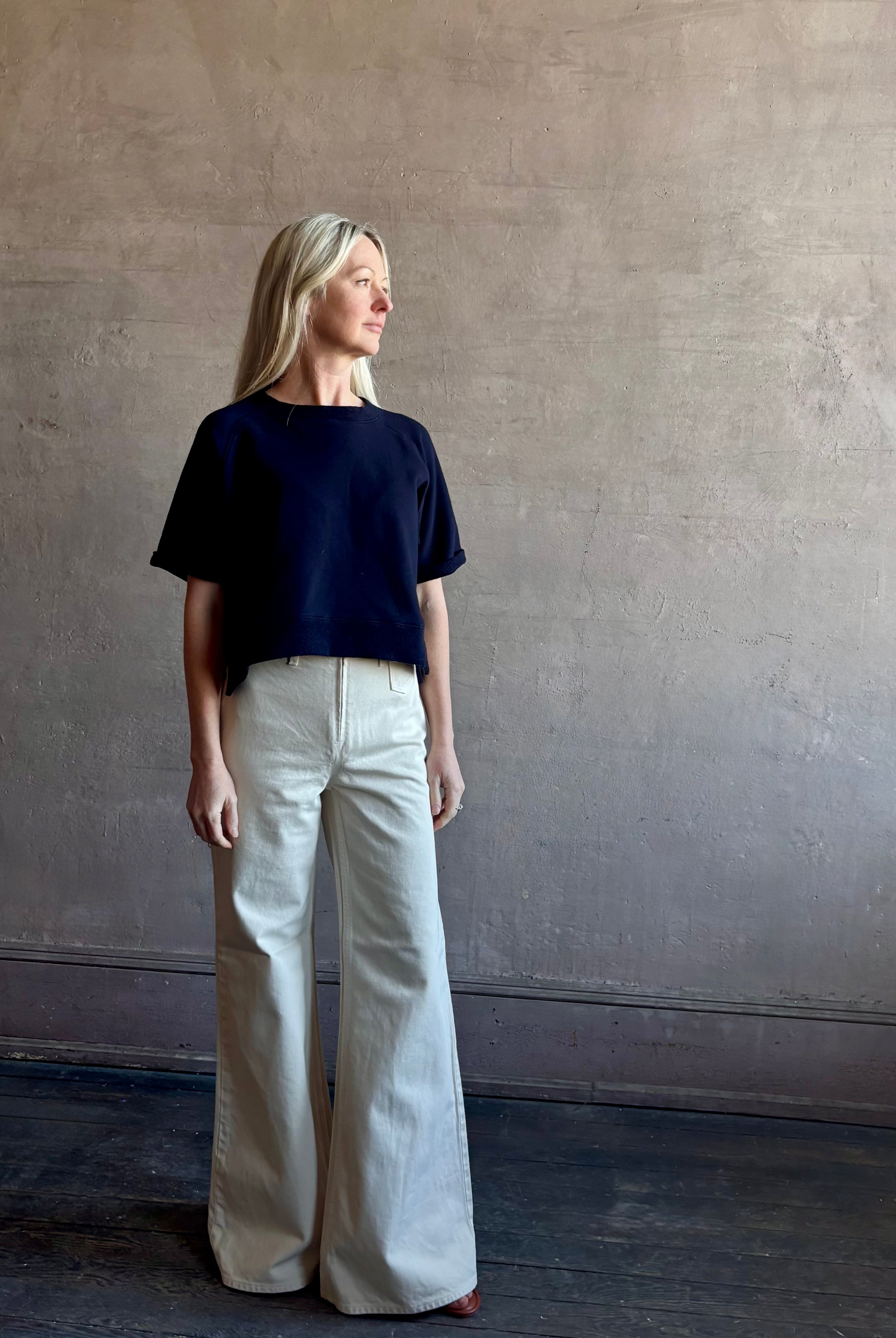 Mature woman waring the Slouchy Rolled Tee Top from TWP luxury women's designer tee rendered in a versatile navy blue and crafted from 100% cotton with short sleeves and crew neckline