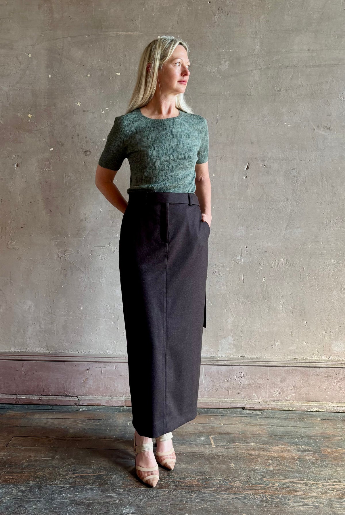 Mature woman wearing TWP Slit Pencil Skirt in Chocolate Brown a sophisticated wool-cashmere blend with tailored waist and front zipper and hook and bar closure
