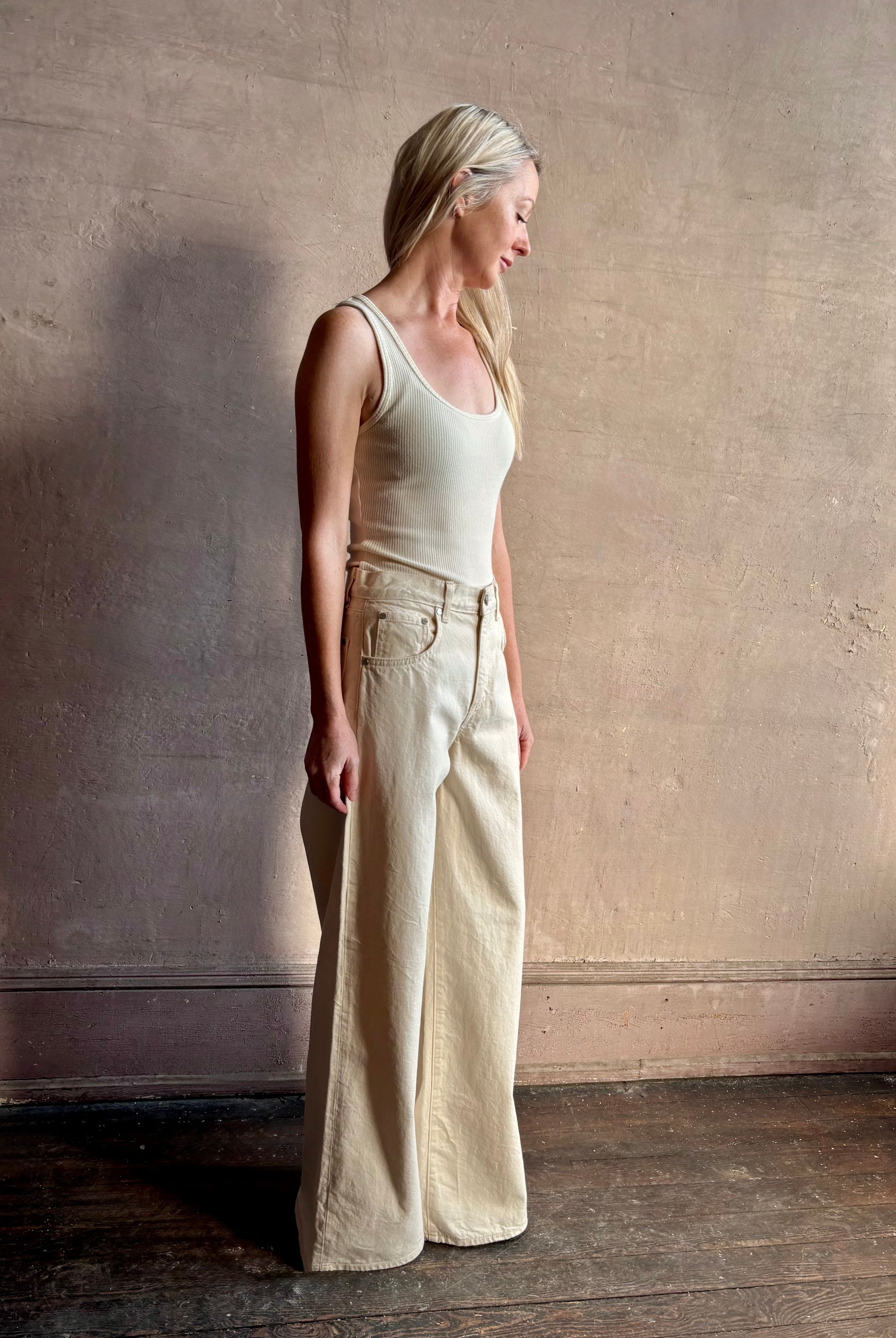 Mature woman wearing premium cotton TWP Tiny Dancer rigid denim with relaxed high rise and wide leg in Natural