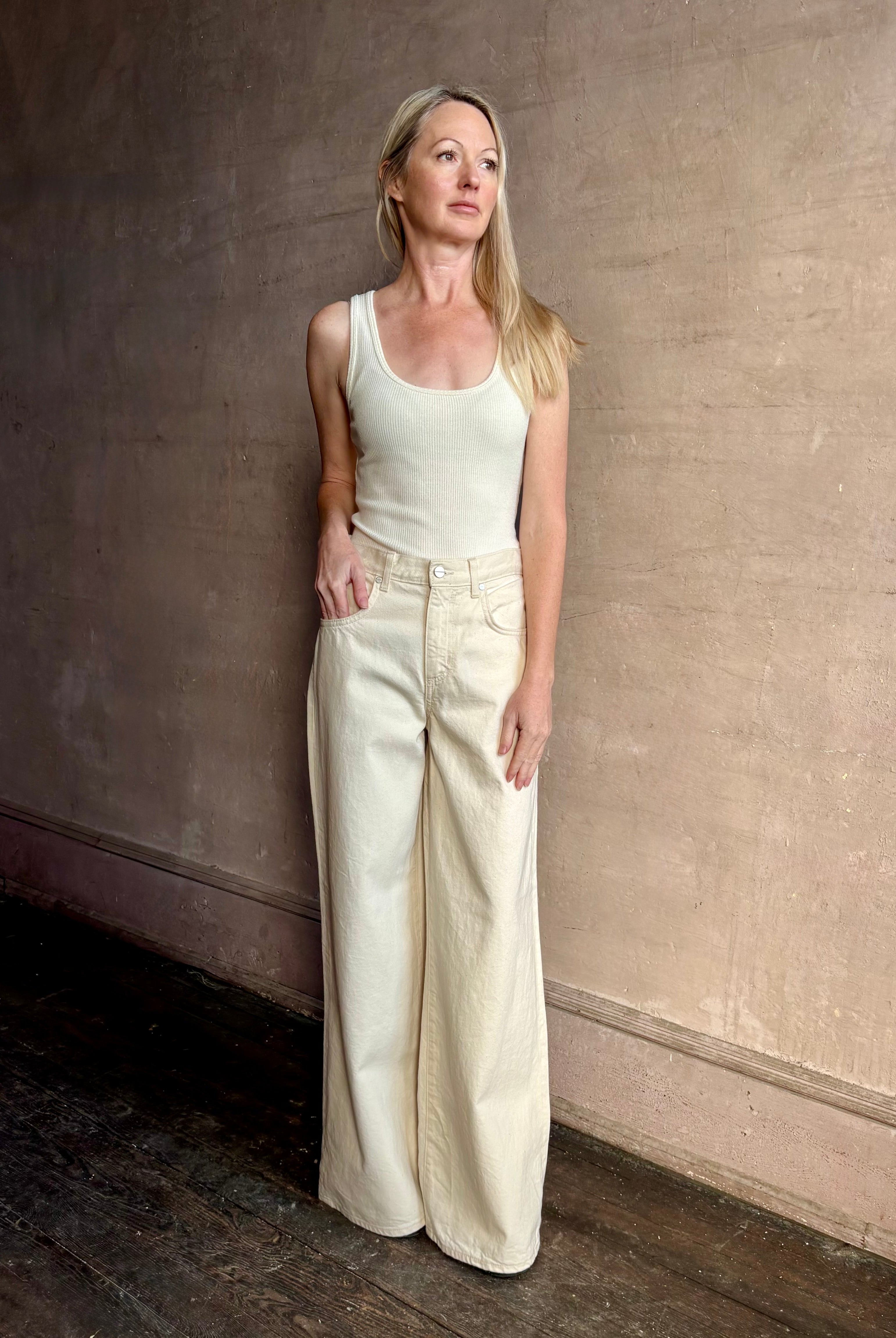 Mature woman wearing premium cotton TWP Tiny Dancer rigid denim with relaxed high rise and wide leg in Natural