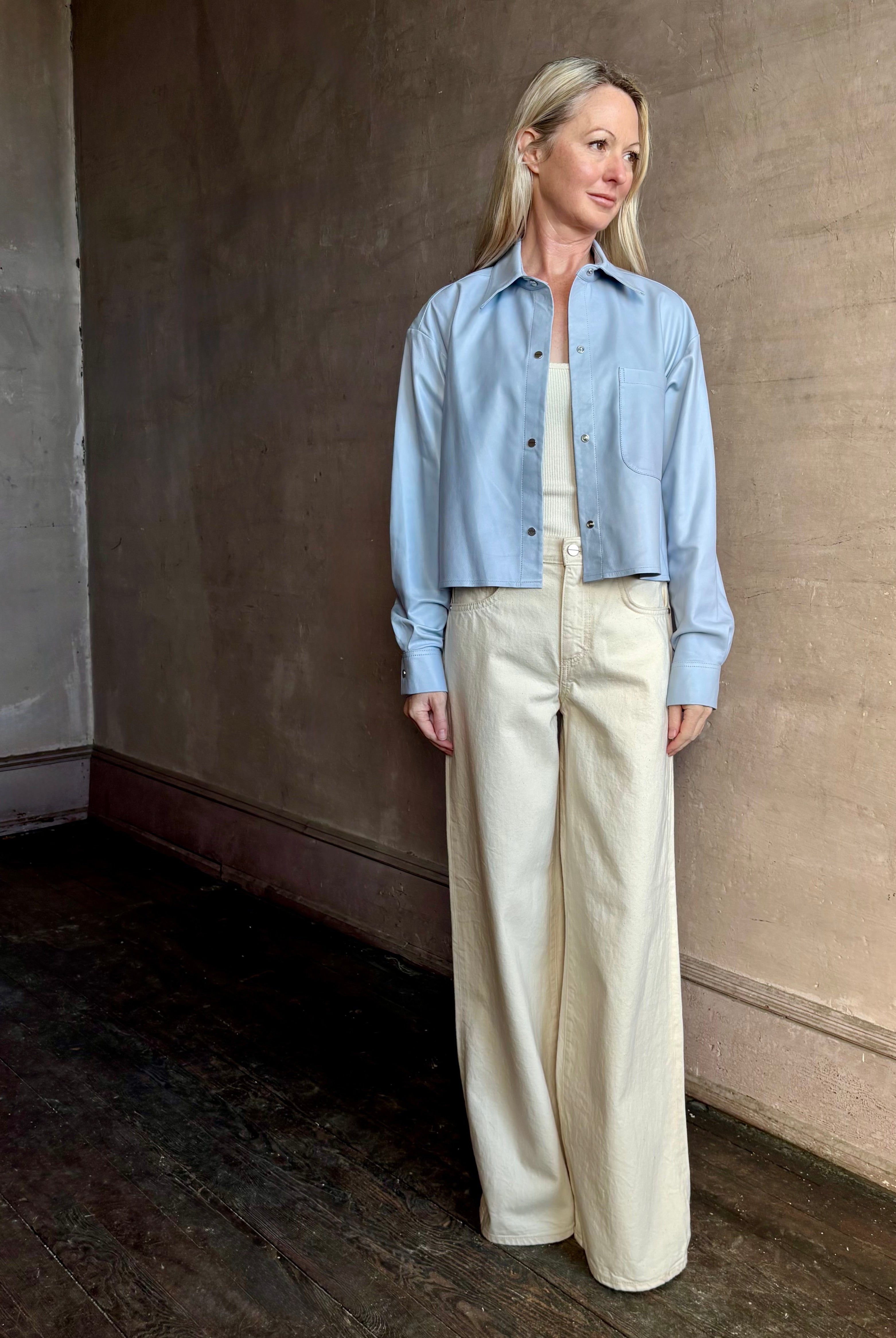 Mature woman wearing premium cotton TWP Tiny Dancer rigid denim with relaxed high rise and wide leg in Natural