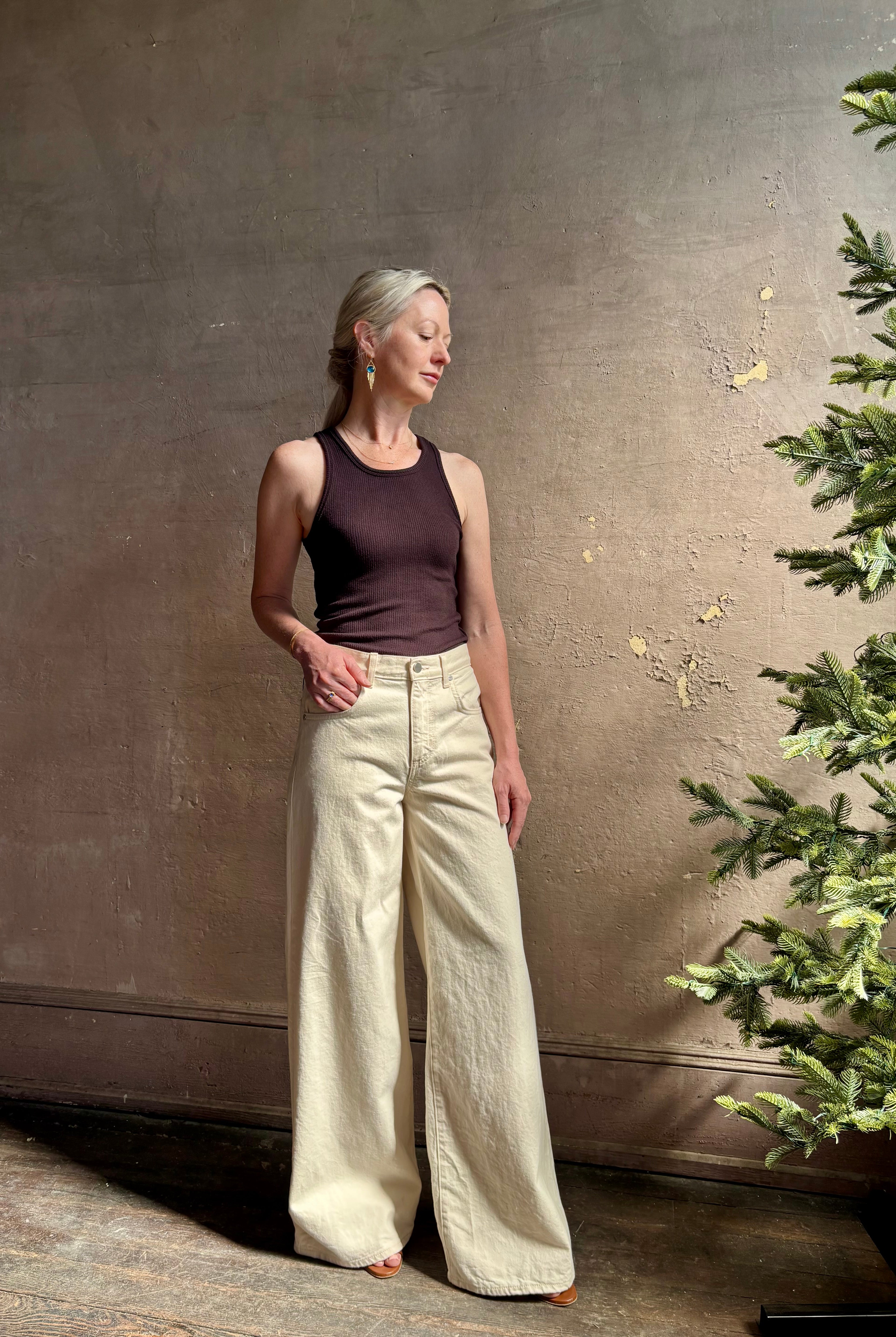 Mature woman wearing premium cotton TWP Tiny Dancer rigid denim with relaxed high rise and wide leg in Natural