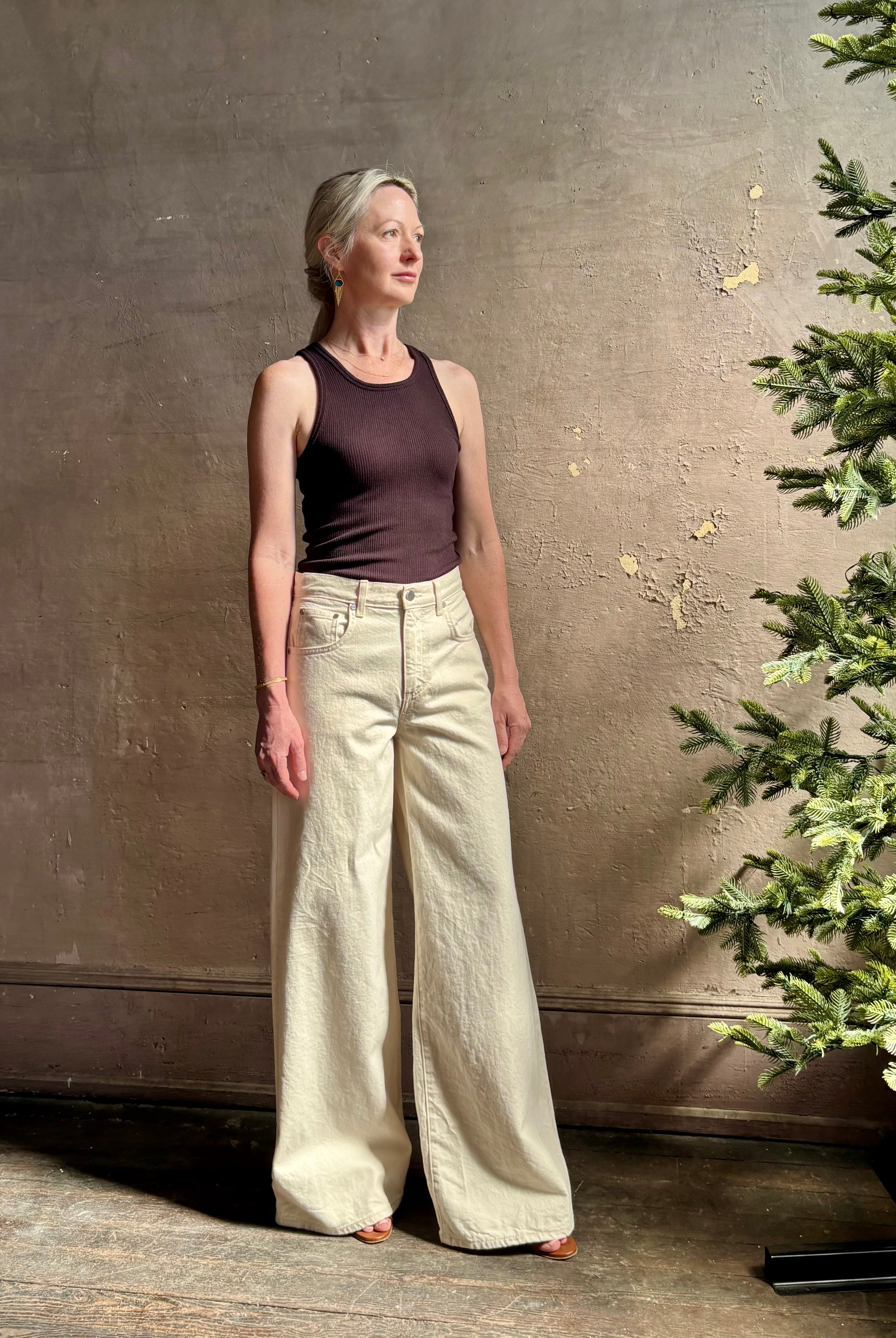 Mature woman wearing premium cotton TWP Tiny Dancer rigid denim with relaxed high rise and wide leg in Natural