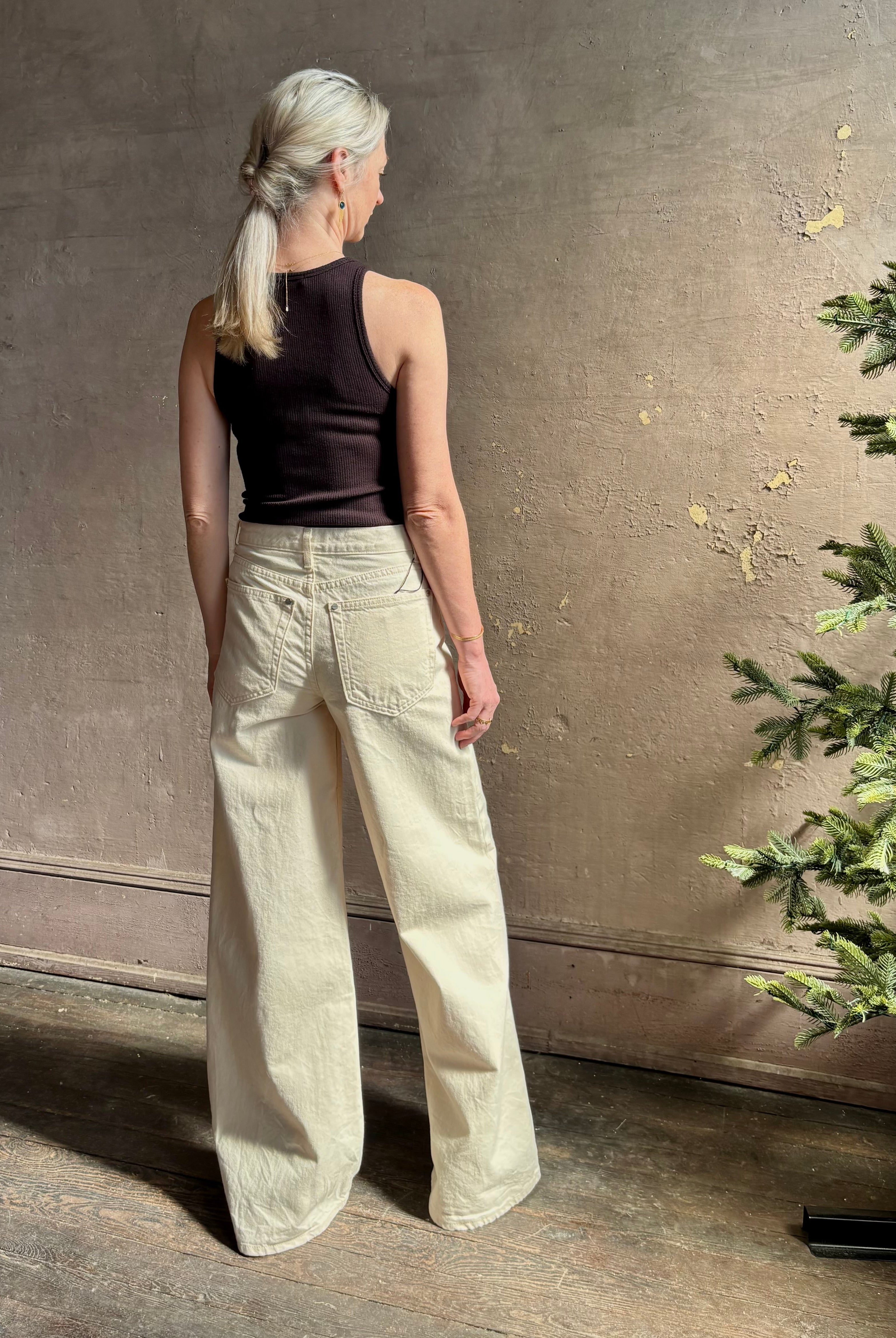Mature woman wearing premium cotton TWP Tiny Dancer rigid denim with relaxed high rise and wide leg in Natural
