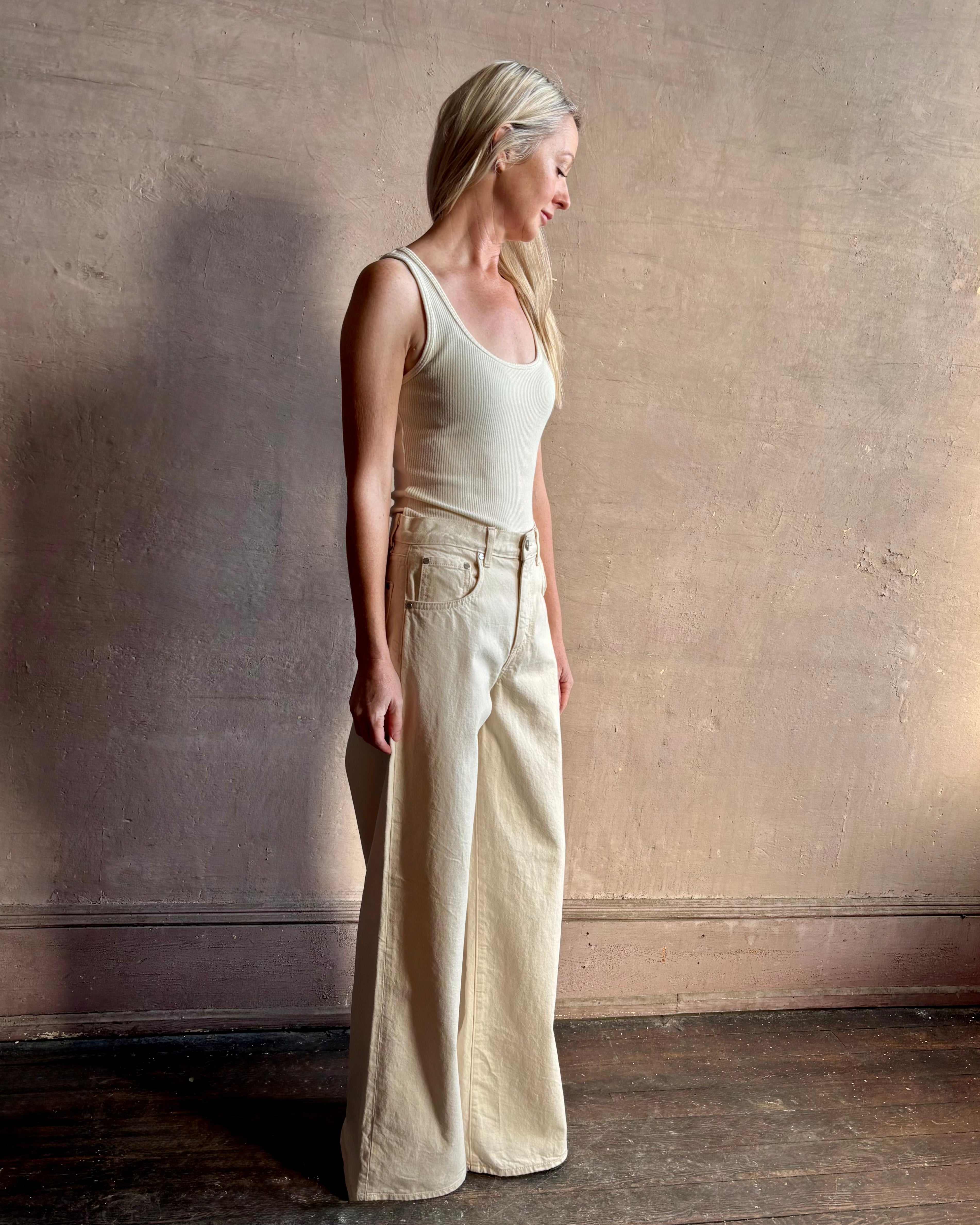 Image of woman wearing premium cotton TWP Tiny Dancer rigid denim with relaxed high rise and wide leg in Natural