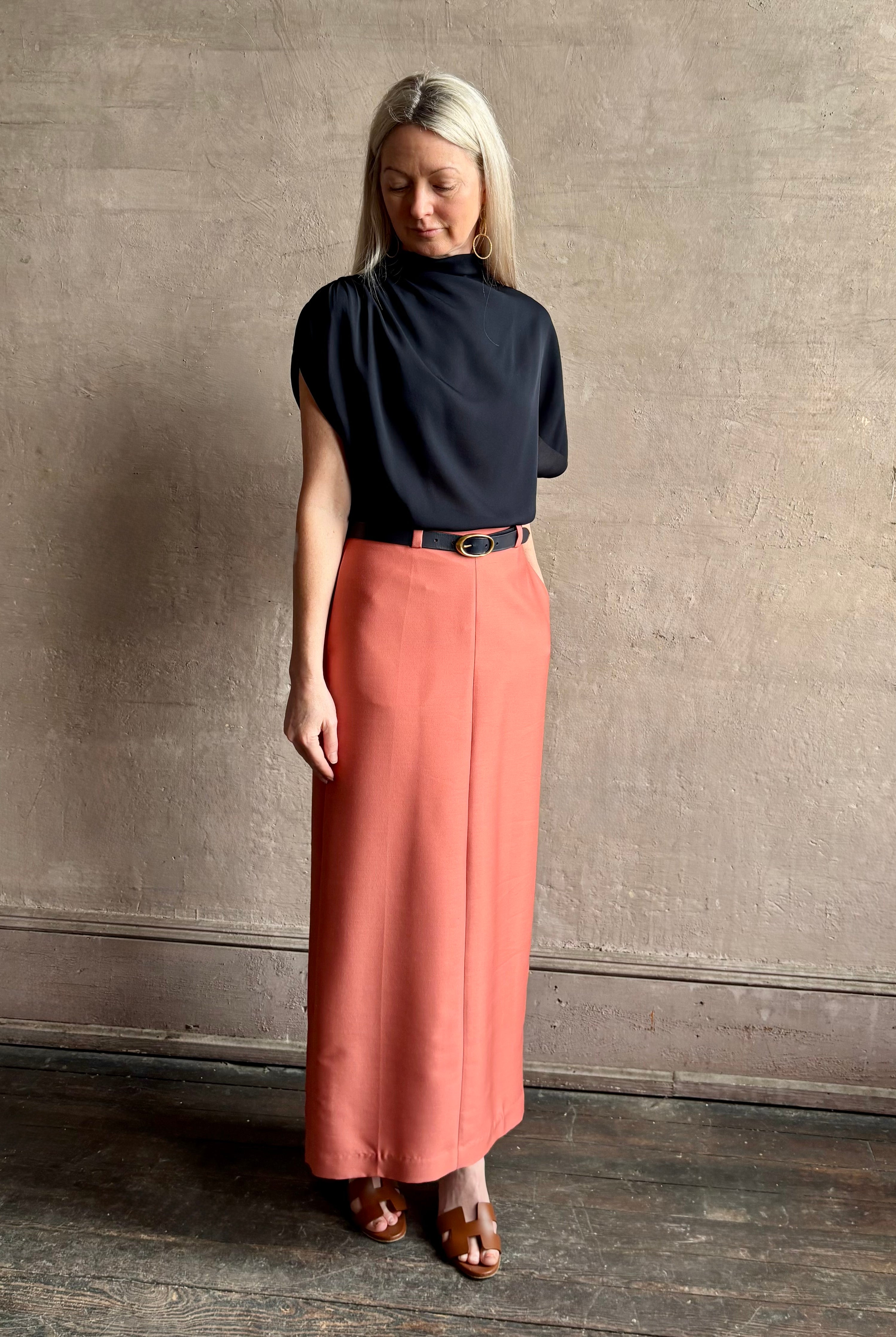 Mature woman wearing an asymmetrical navy blue silk blouse by New York luxury Women's clothing designer TWP with short sleeves