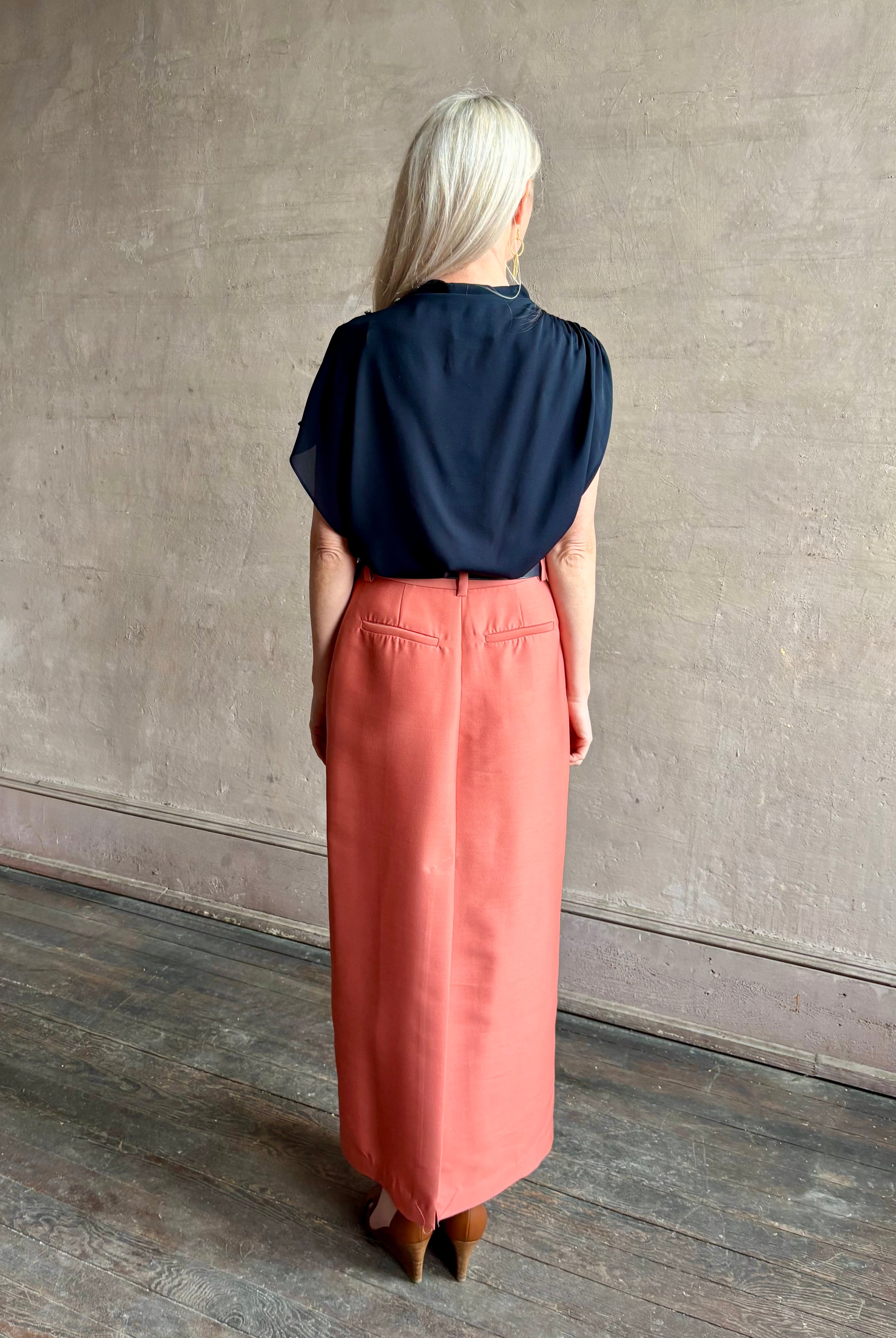 Mature woman wearing an asymmetrical navy blue silk blouse by New York luxury Women's clothing designer TWP with short sleeves