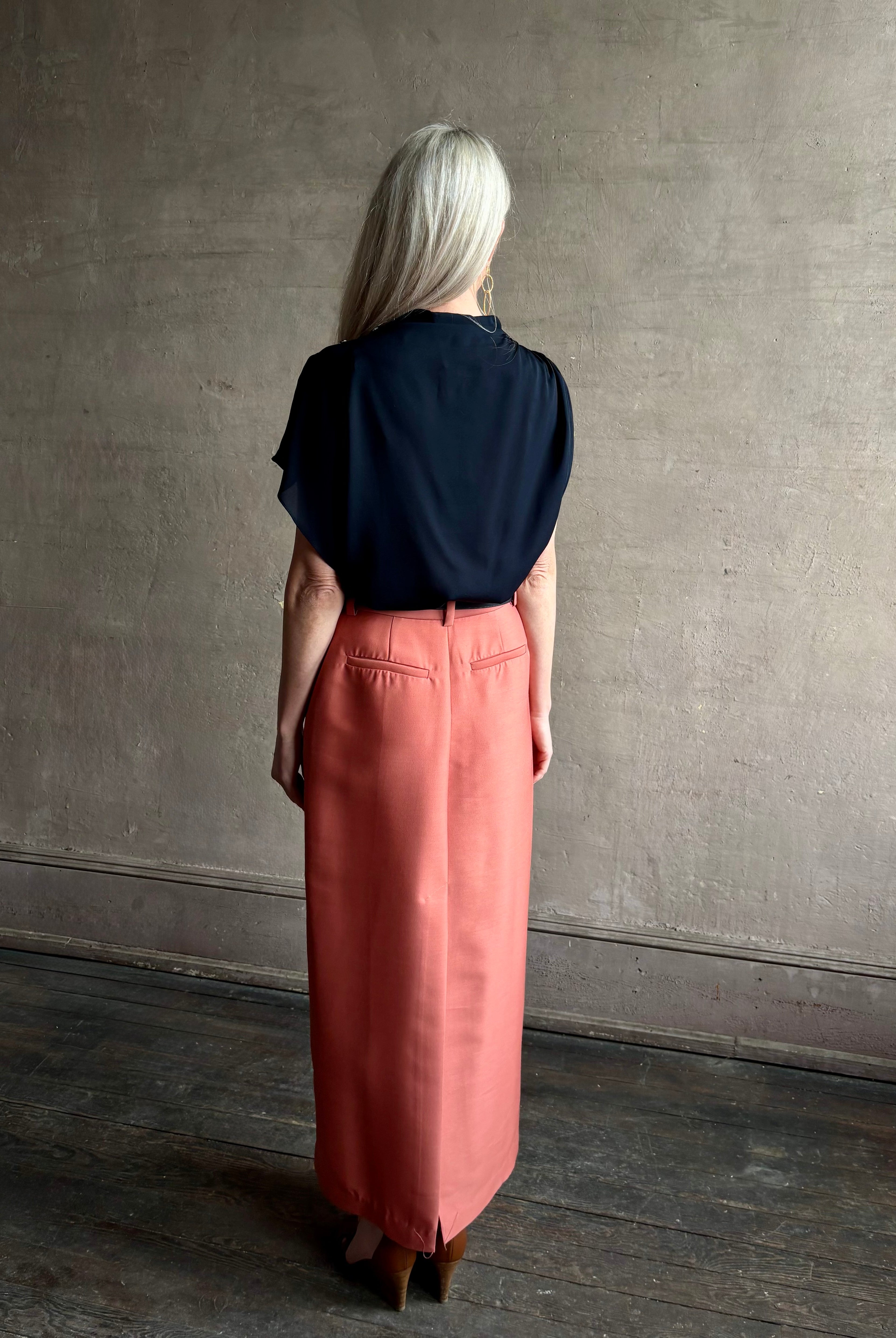 Mature woman wearing an asymmetrical navy blue silk blouse by New York luxury Women's clothing designer TWP with short sleeves