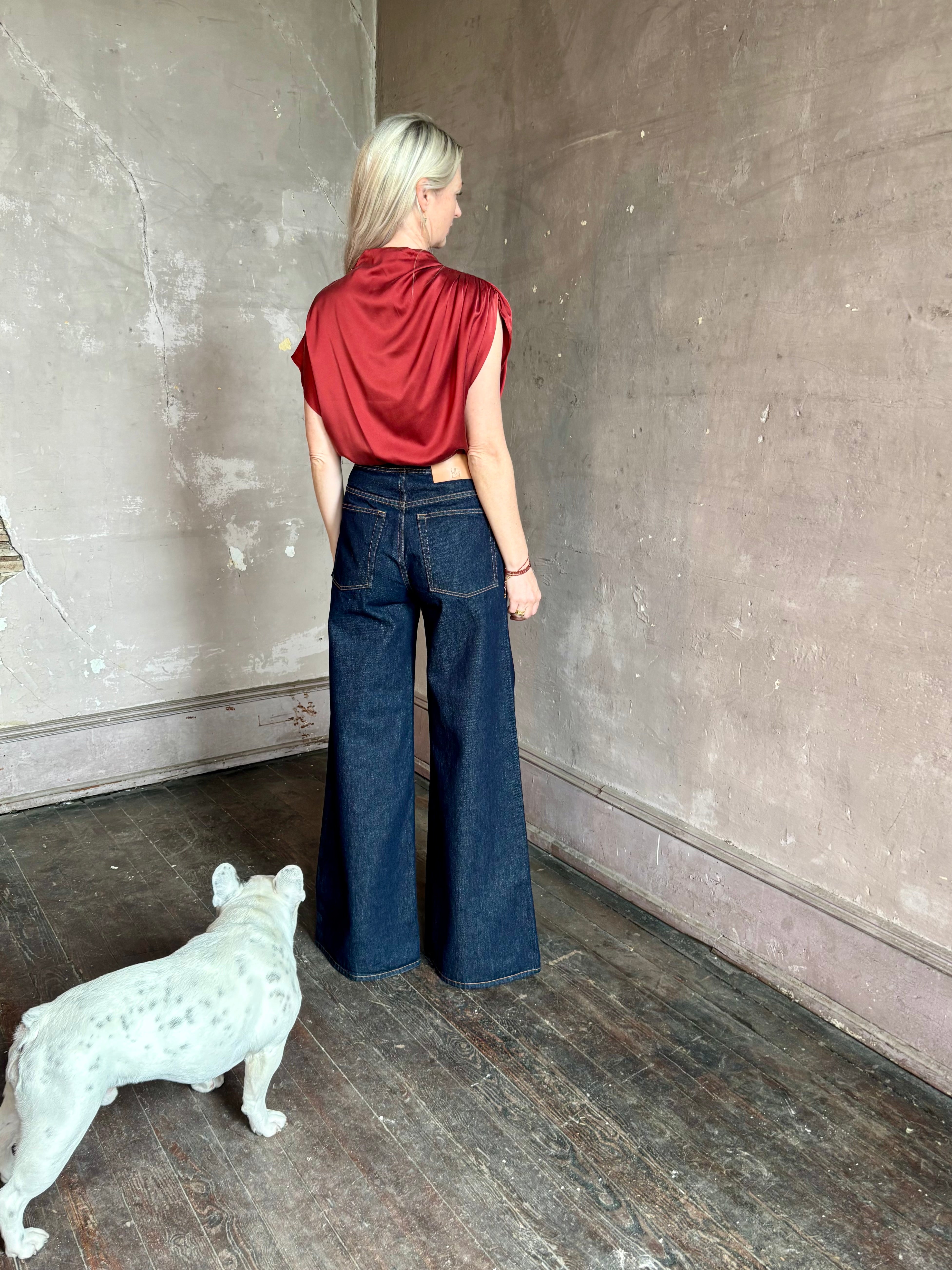 Mature woman wearing Wish You Would blouse from TWP rendered in a rich currant red and crafted from a luxurious silk blend with a mock neck, asymetrical design and draping short sleeves shoulder button closure
