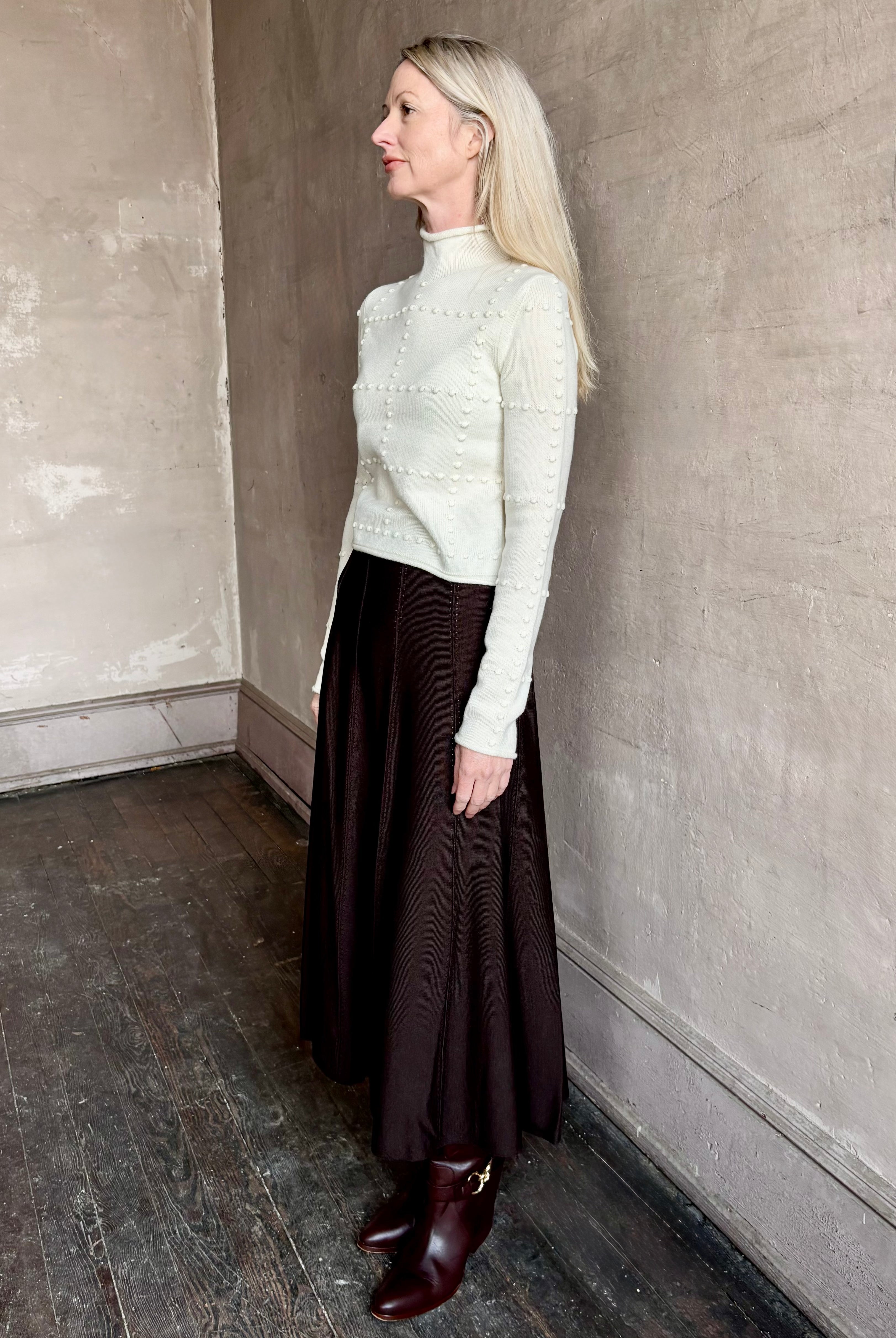 Woman wearing TWP Willow Knit Skirt in chocolate brown premium Merino Wool Knit A-line Skirt