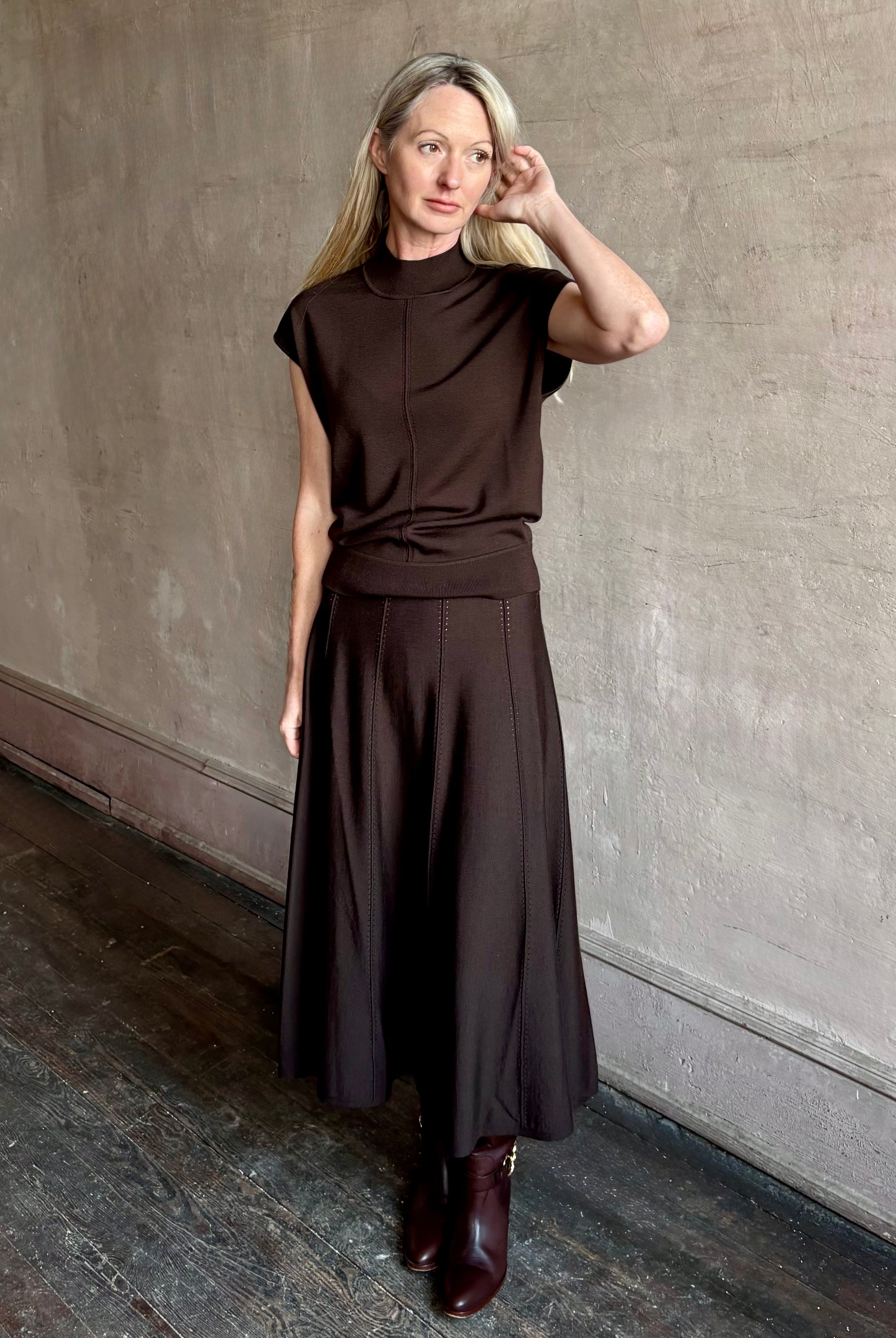 Woman wearing TWP Willow Knit Skirt in chocolate brown premium Merino Wool Knit A-line Skirt and matching top set