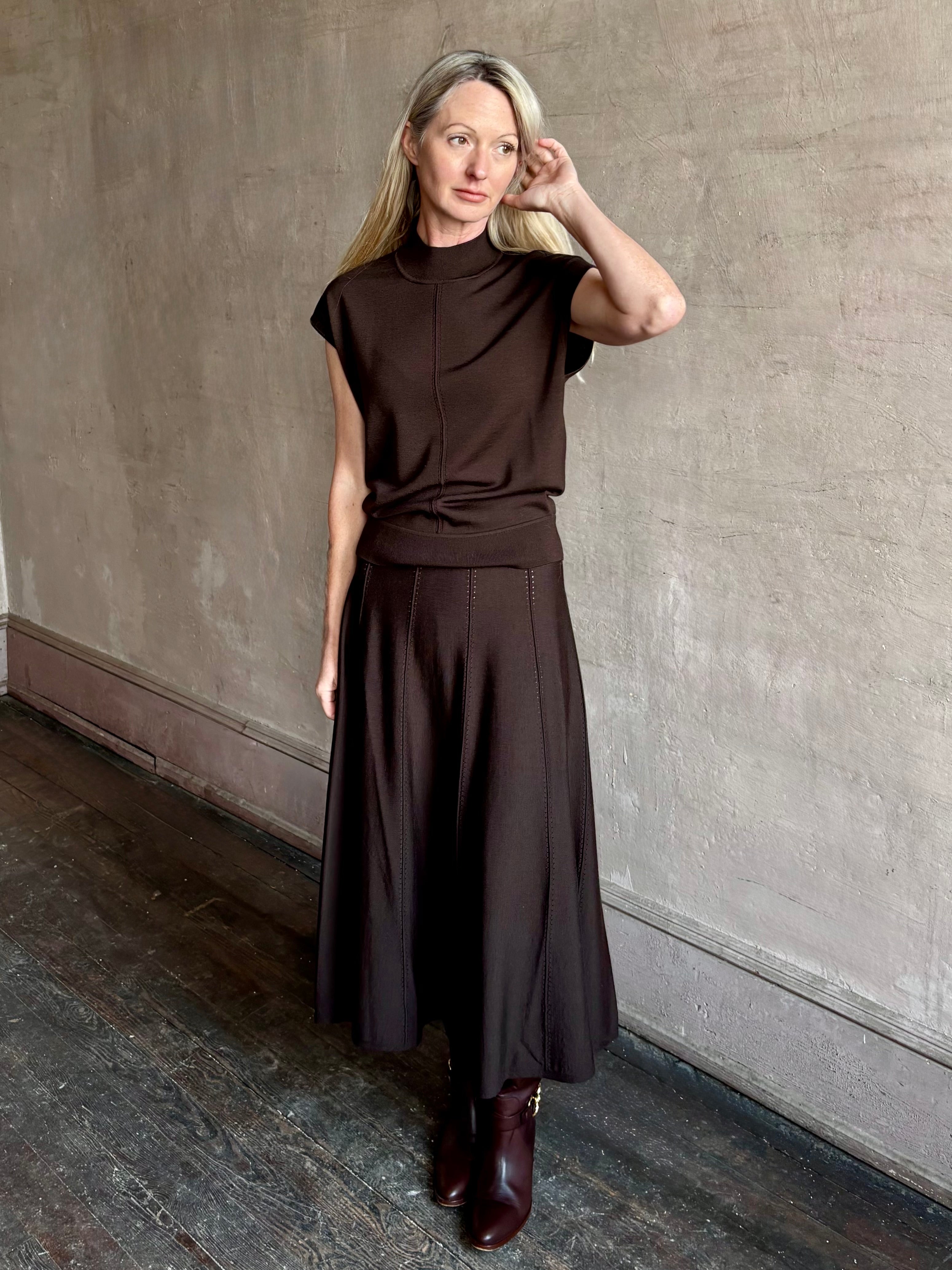 Woman wearing TWP Willow Knit Skirt in chocolate brown premium Merino Wool Knit A-line Skirt and matching top set
