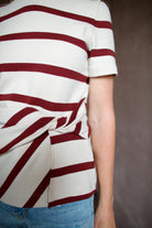 Mature model wearing a premium cream and burgundy striped t-shirt from Tanya Taylor with twist front
