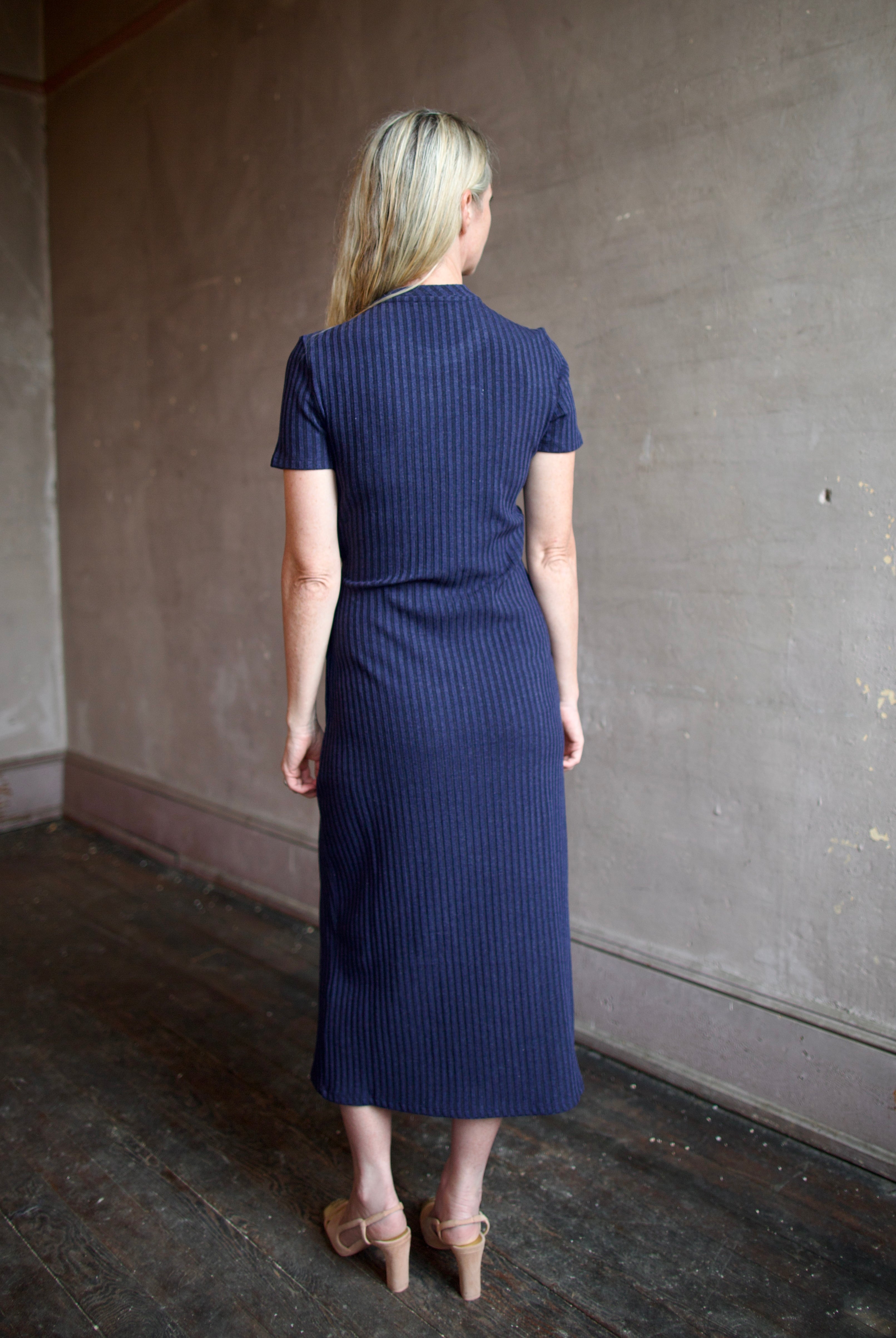 Model wearing a flattering elevated casual ribbed blue and black dress by designer Tanya Taylor