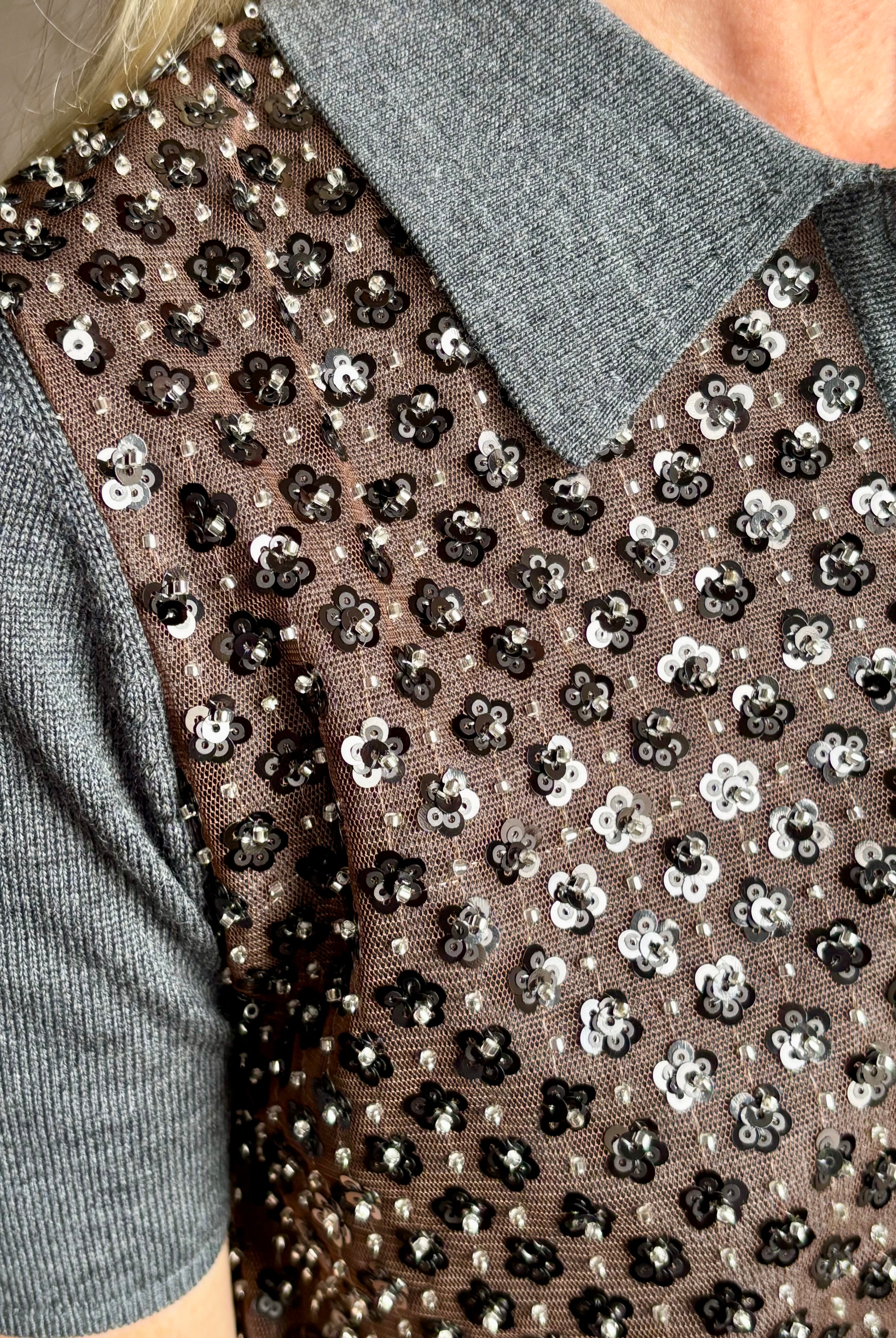 Close-up image of American designer Tanya Taylor Camilla Knit top with a brown sequin floral patterned over a gray extra fine merino wool polo sweater