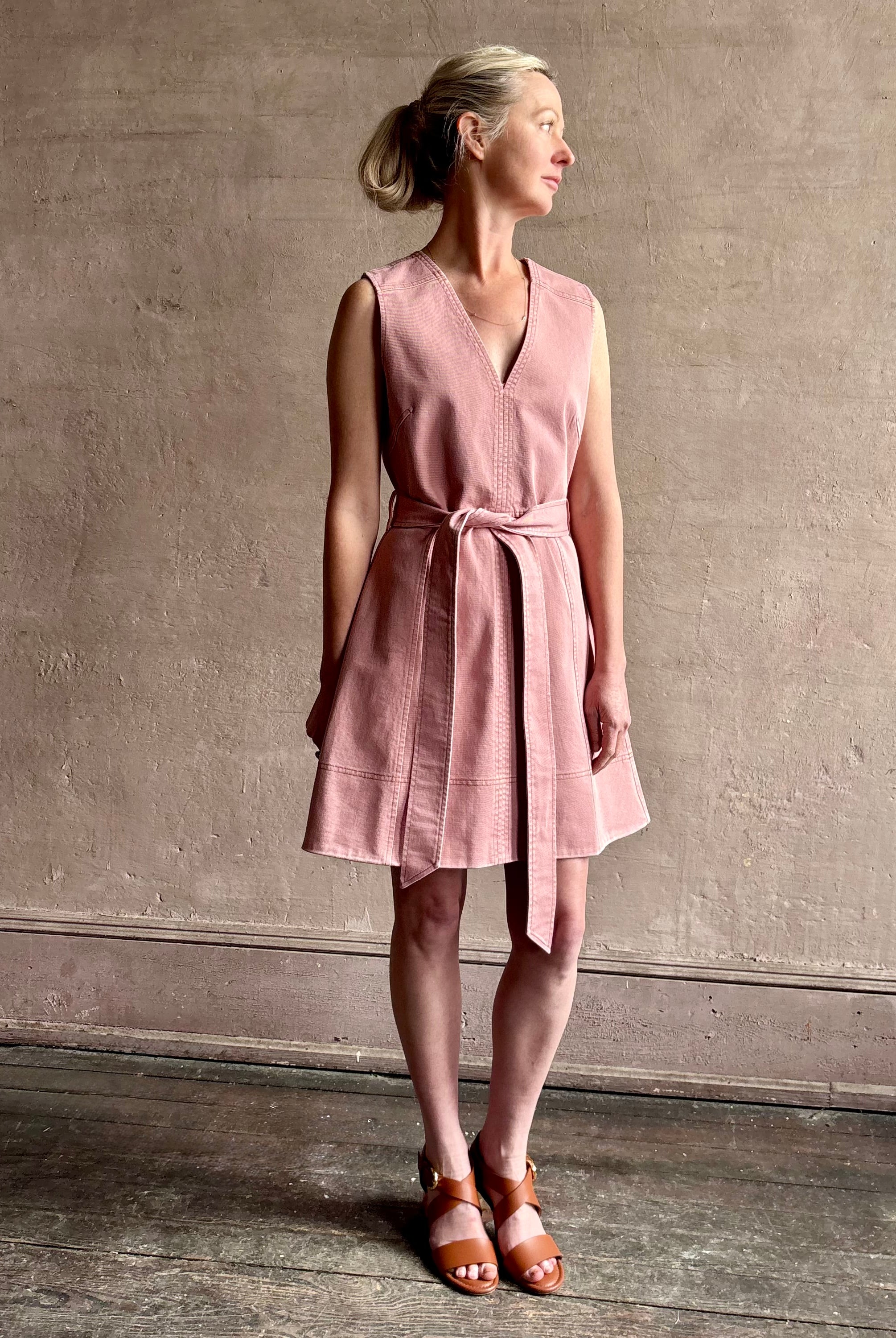 mature woman wearing designer Tanya Taylor Reina cotton denim short sleeveless Dress in Roqua pink with v-neck