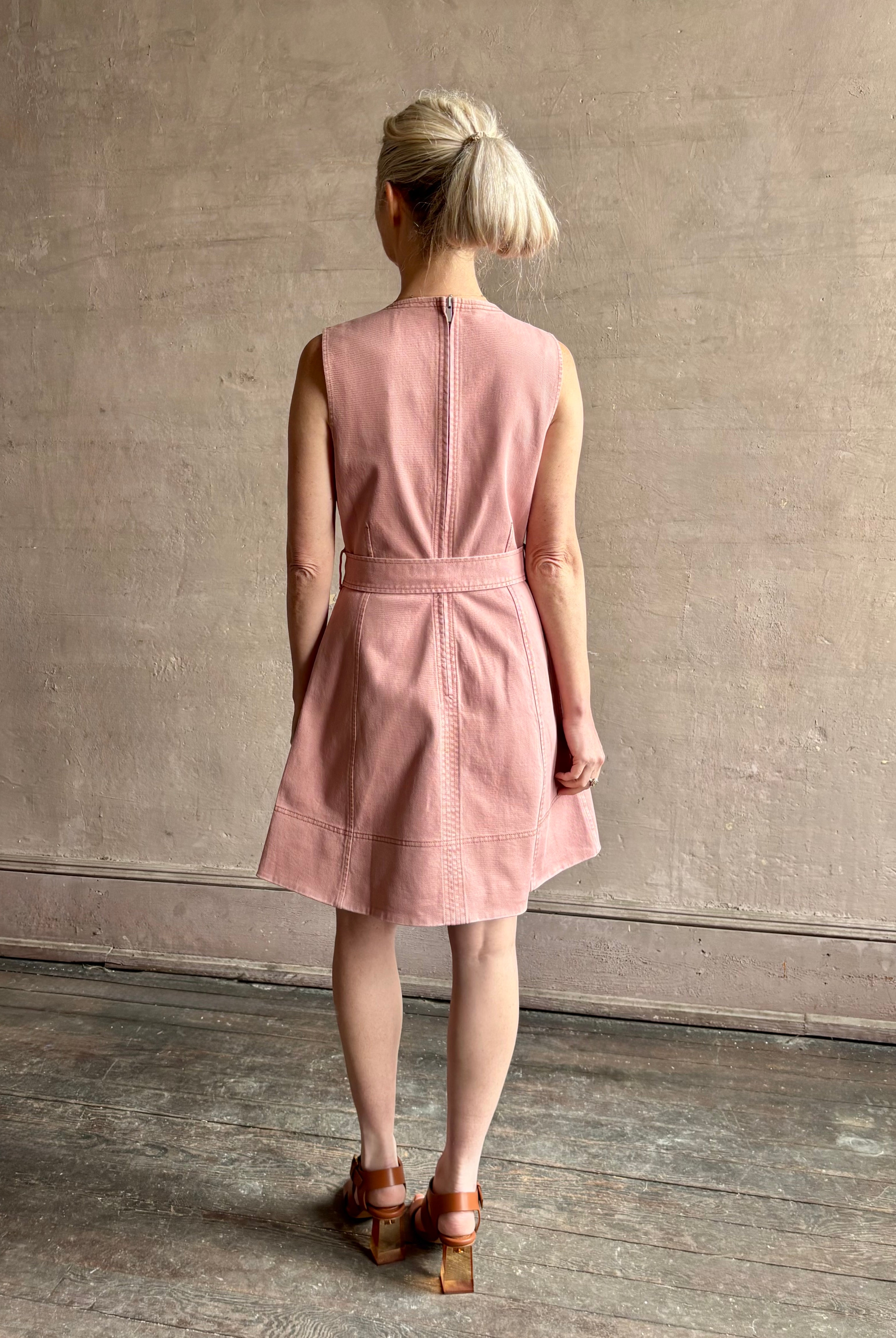 mature woman wearing designer Tanya Taylor Reina cotton denim short sleeveless Dress in Roqua pink with v-neck and expert tailoring