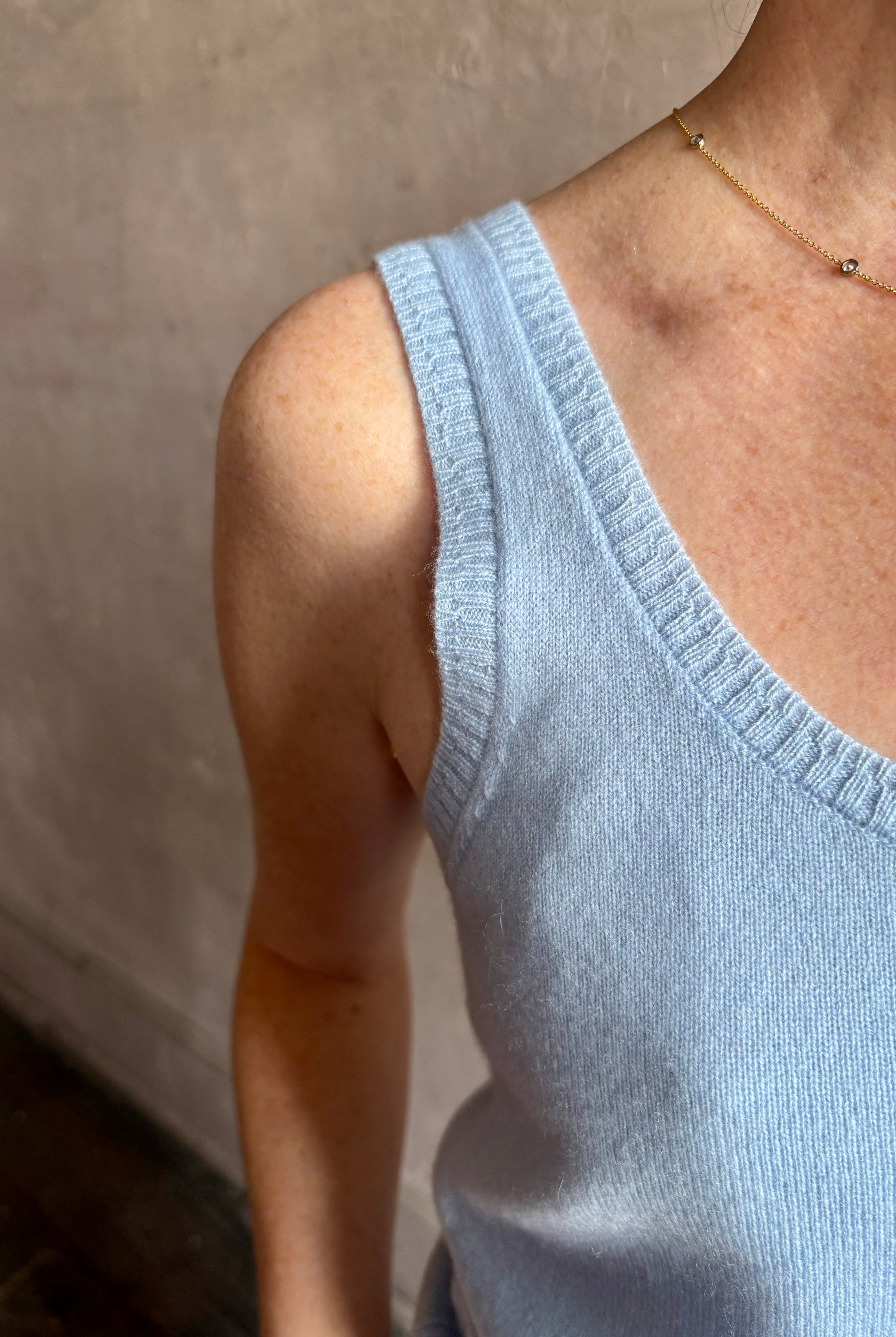 Image of woman wearing luxury cashmere knitwear Tanya Taylor Rory Cashmere Tank top in Pale Blue with a feminine scoop neckline
