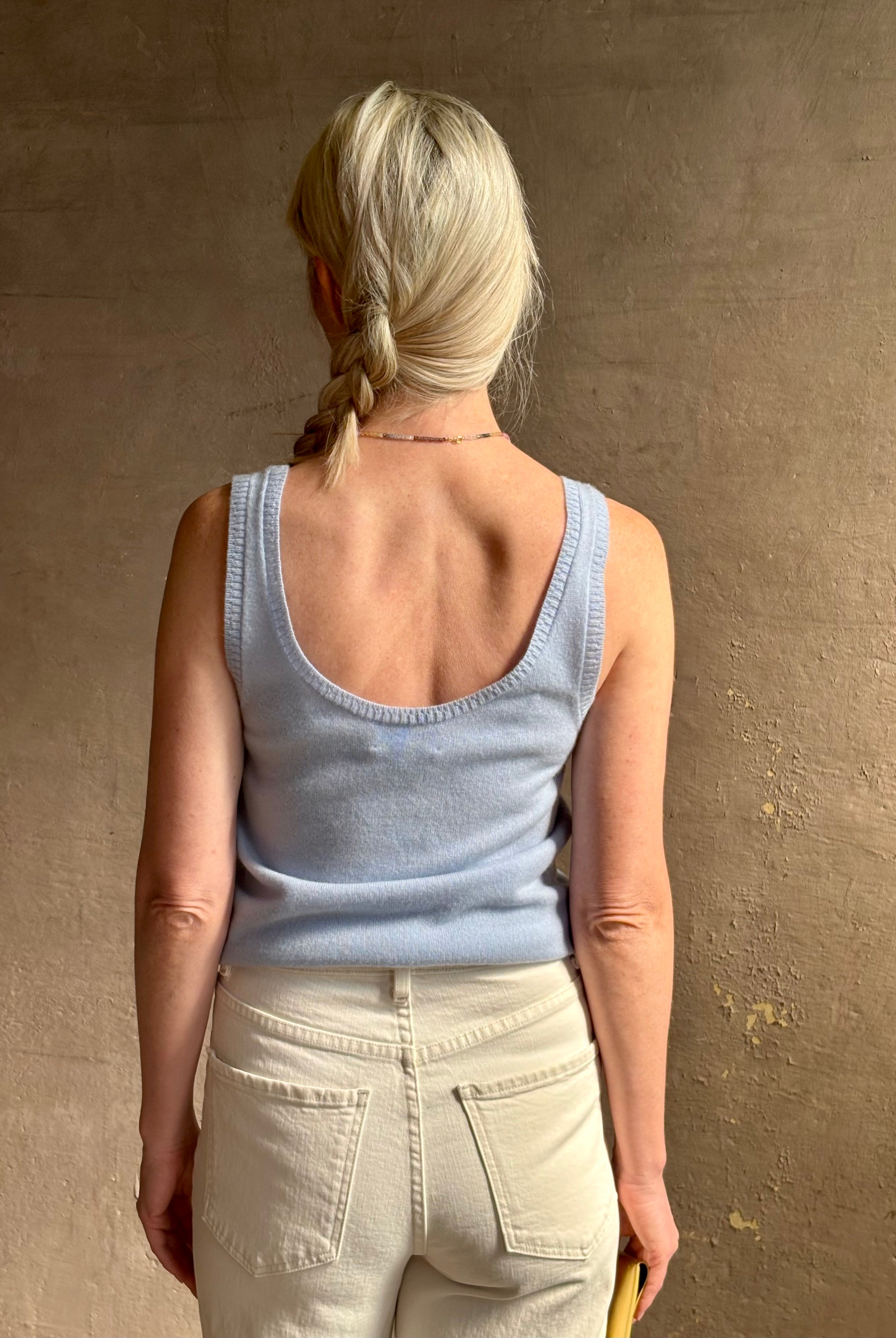 Image of woman wearing luxury cashmere knitwear Tanya Taylor Rory Cashmere Tank top in Pale Blue with a feminine scoop neckline
