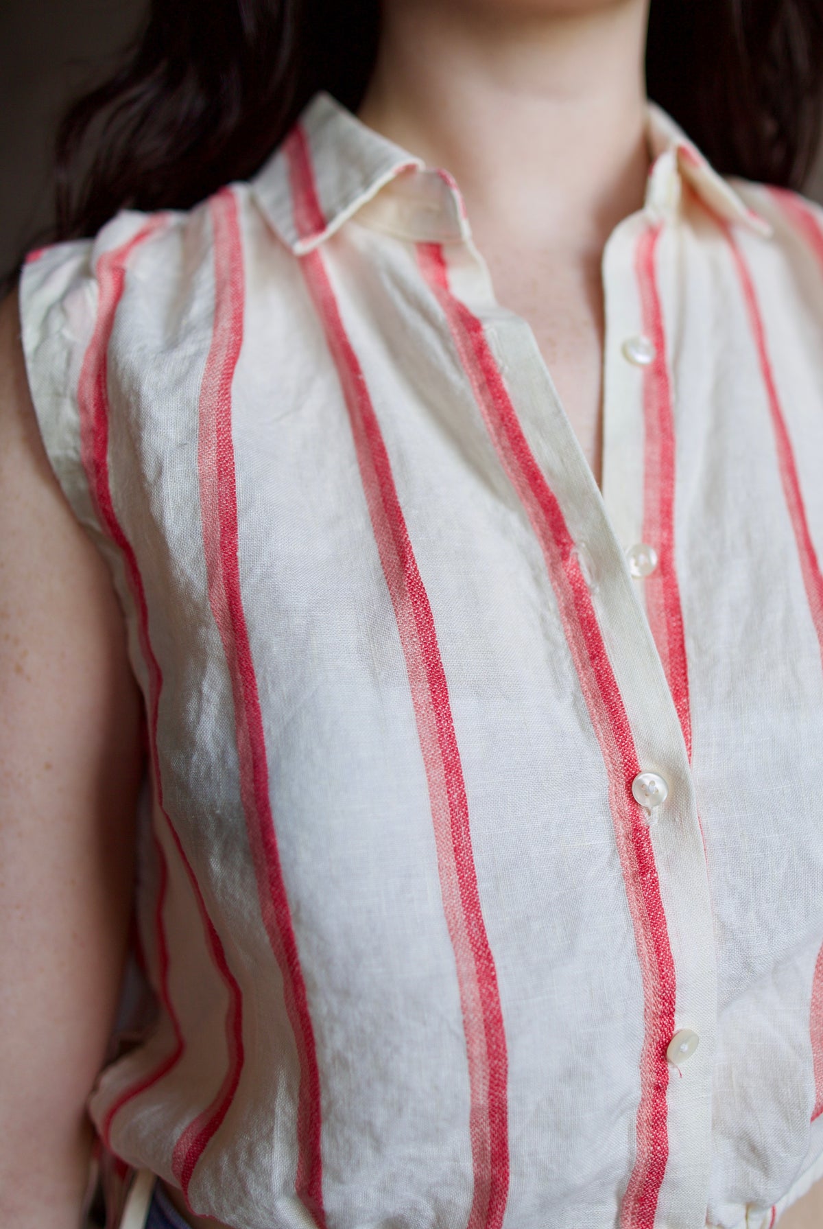 Woman wearing Trovata Ivy cream and pink striped linen Shirt in Pomme Stripe button front, drawstring waist, and cropped fit. Sun-faded, playful California ease