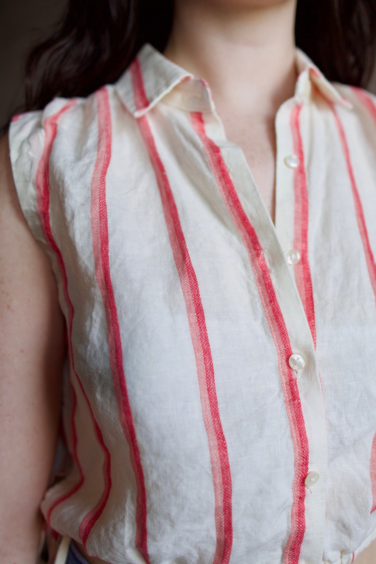 Woman wearing Trovata Ivy cream and pink striped linen Shirt in Pomme Stripe button front, drawstring waist, and cropped fit. Sun-faded, playful California ease