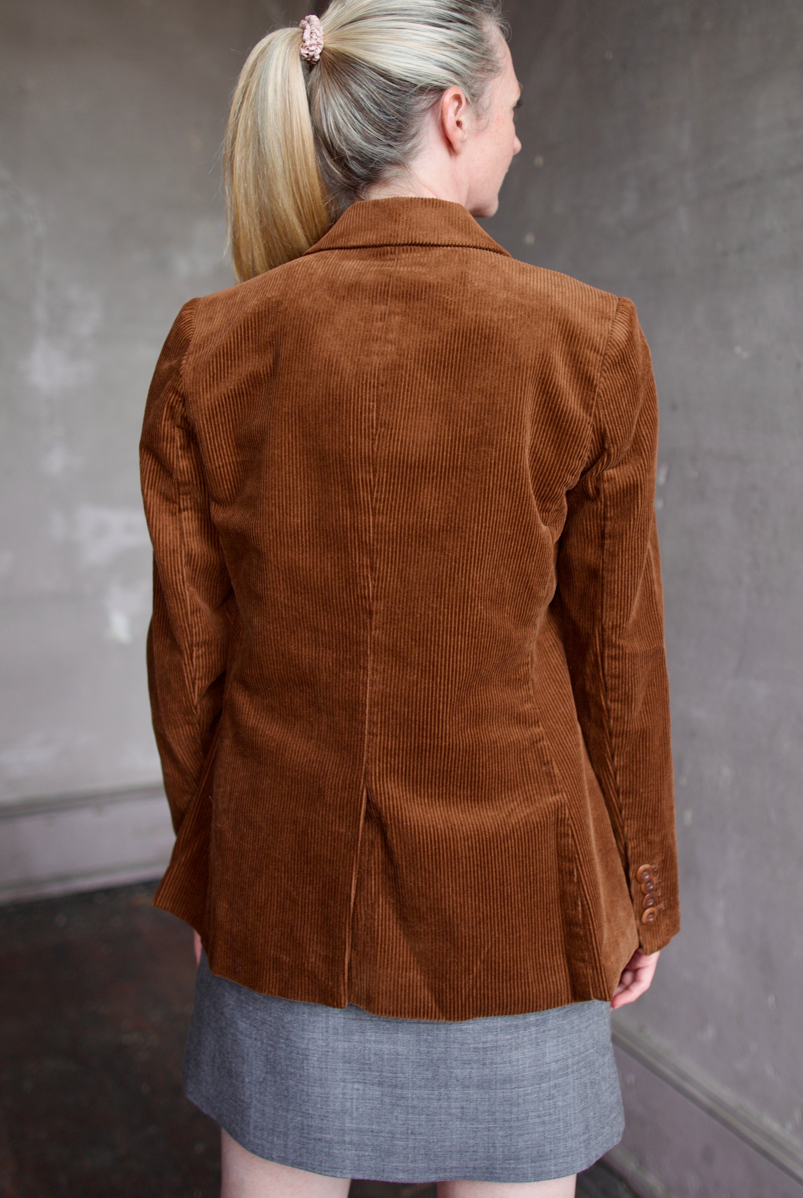 Model wearing the Trovata Skylar brown cotton corduroy blazer and  Apiece Apart grey wool mini skirt