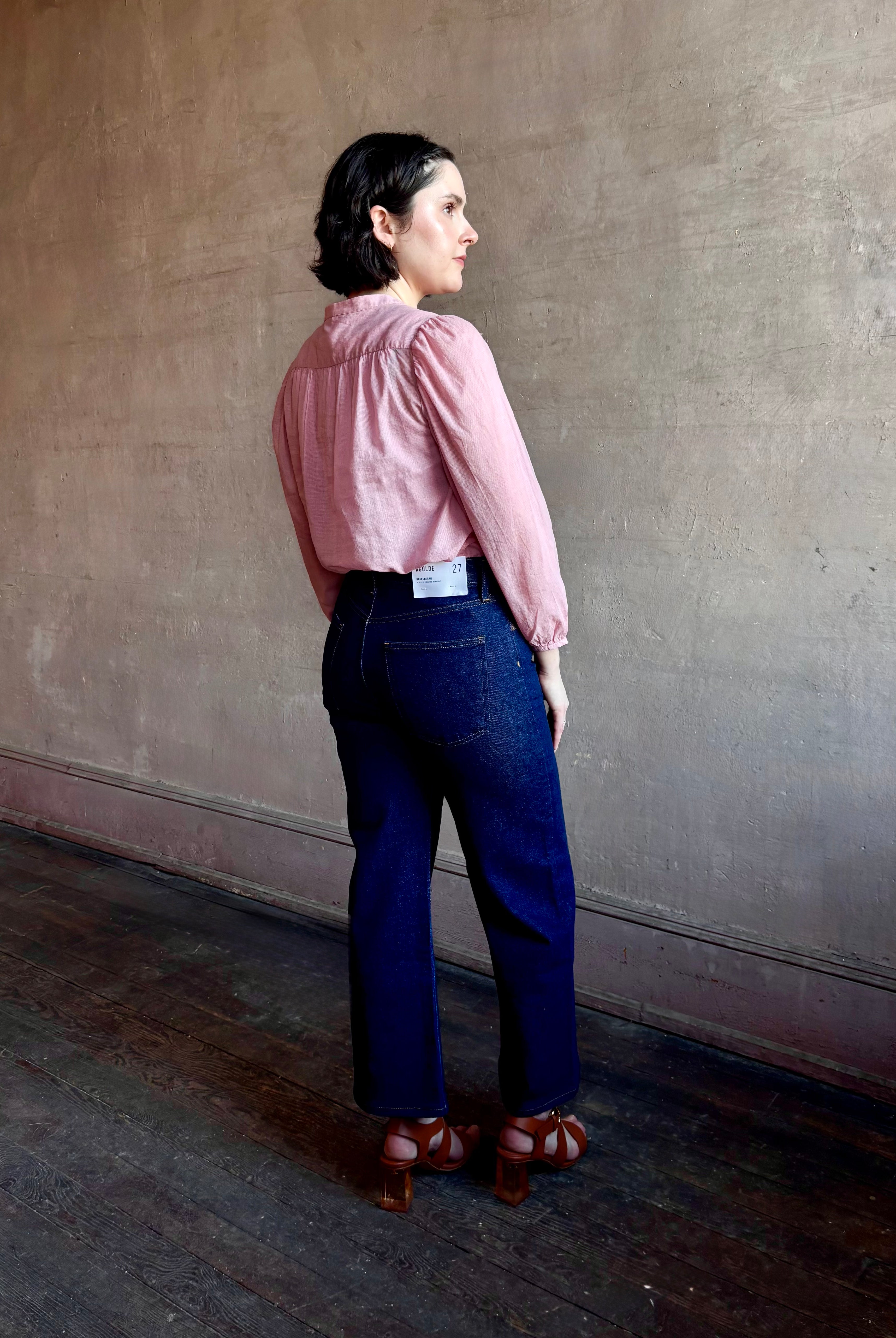 Woman wearing premium lightweight cotton poplin Maisey Blouse by Trovata with long sleeves and v-neck in pink and white tiny Houndstooth print