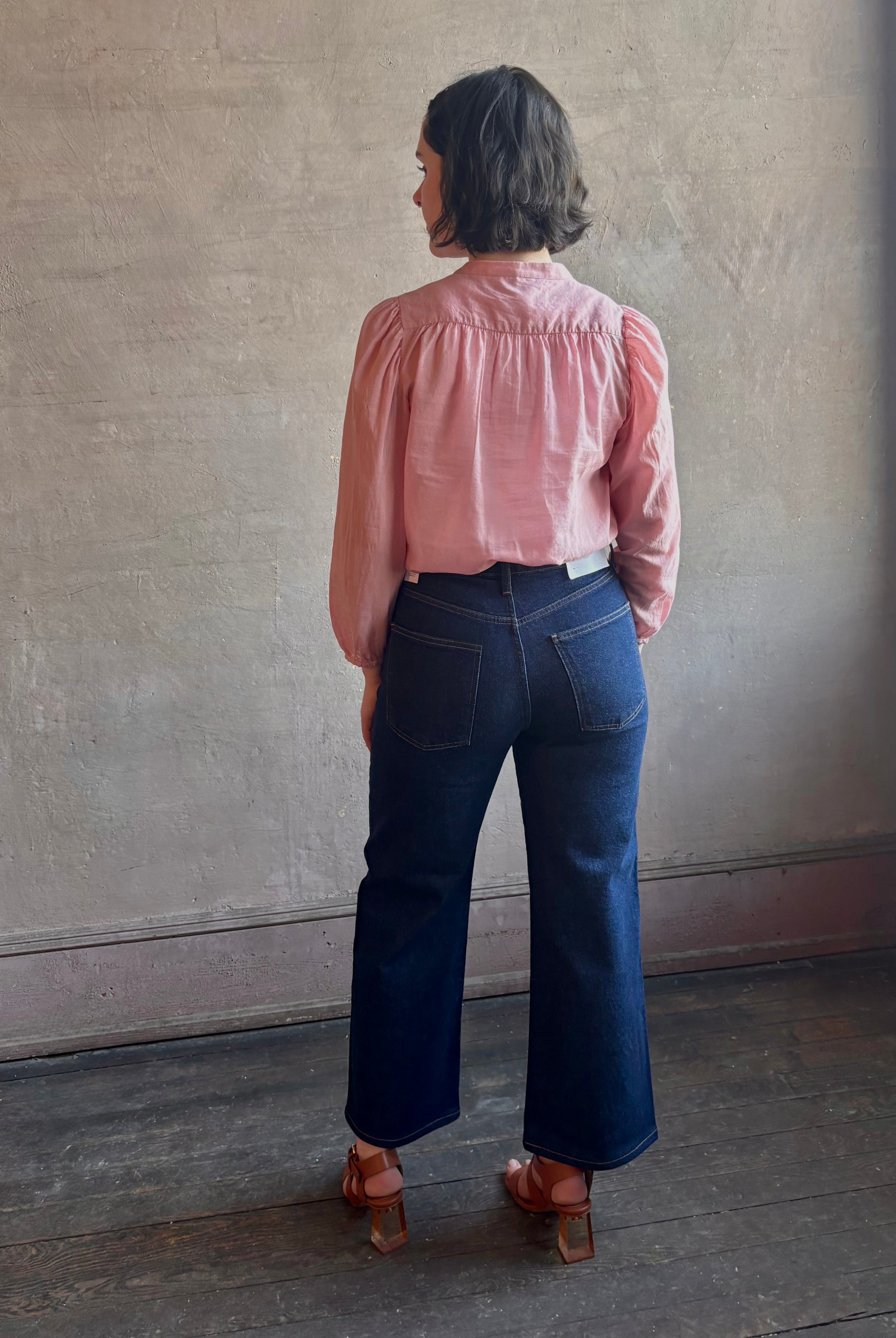 Woman wearing premium lightweight cotton poplin Maisey Blouse by Trovata with long sleeves and v-neck in pink and white tiny Houndstooth print