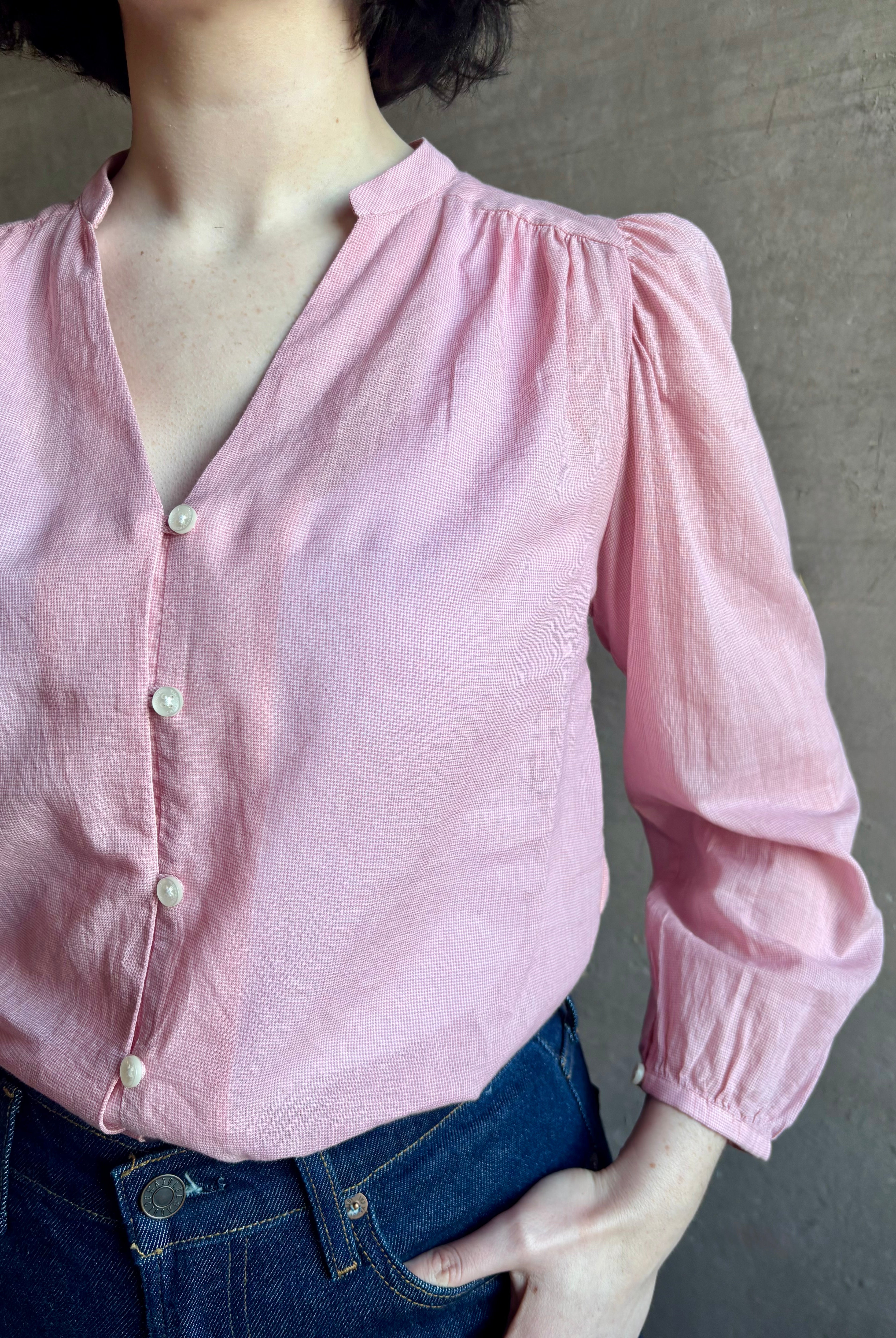 woman wearing premium lightweight cotton poplin Maisey Blouse by Trovata with long sleeves and v-neck in pink and white tiny Houndstooth print