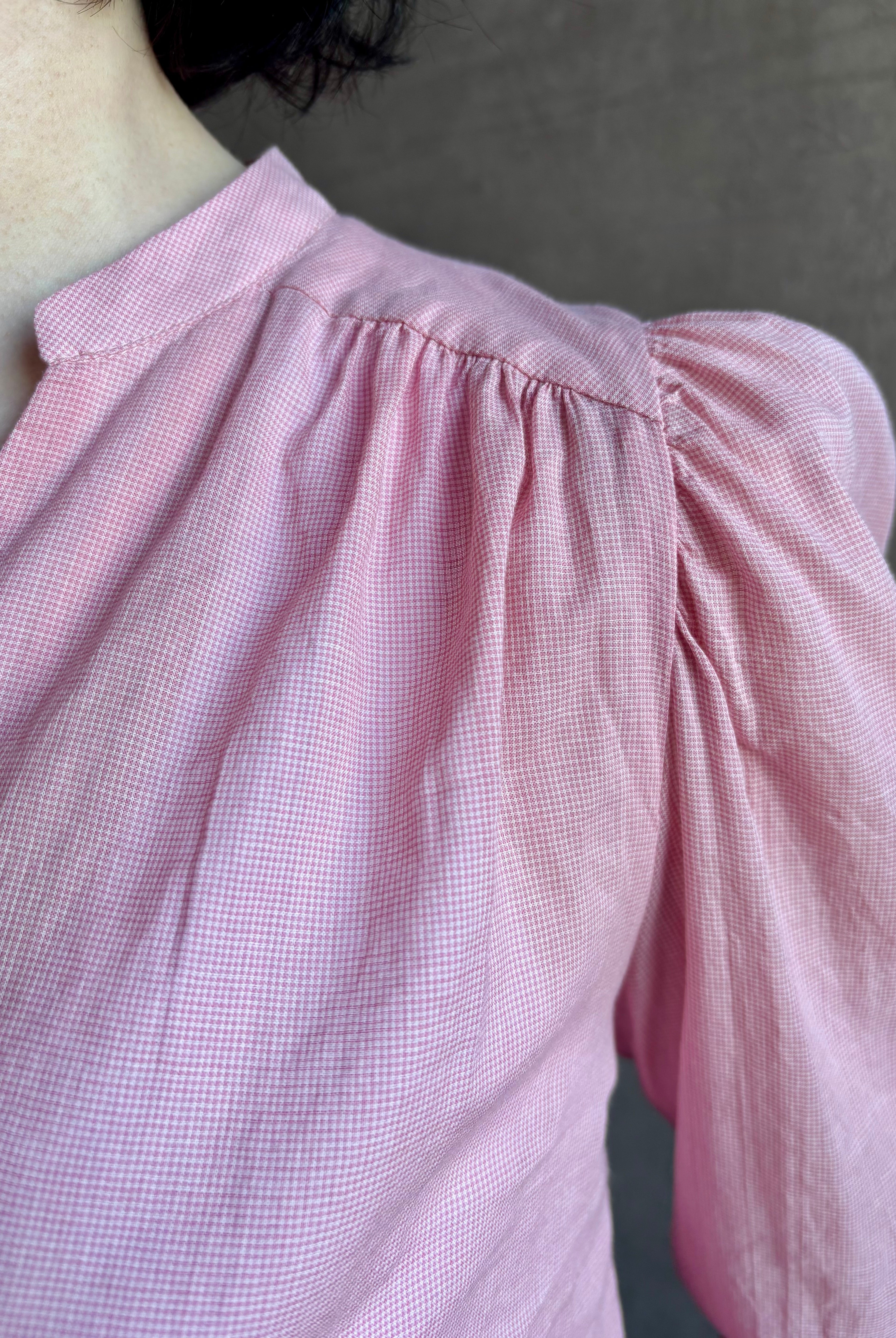 woman wearing premium lightweight cotton poplin Maisey Blouse by Trovata with long sleeves and v-neck in pink and white tiny Houndstooth print