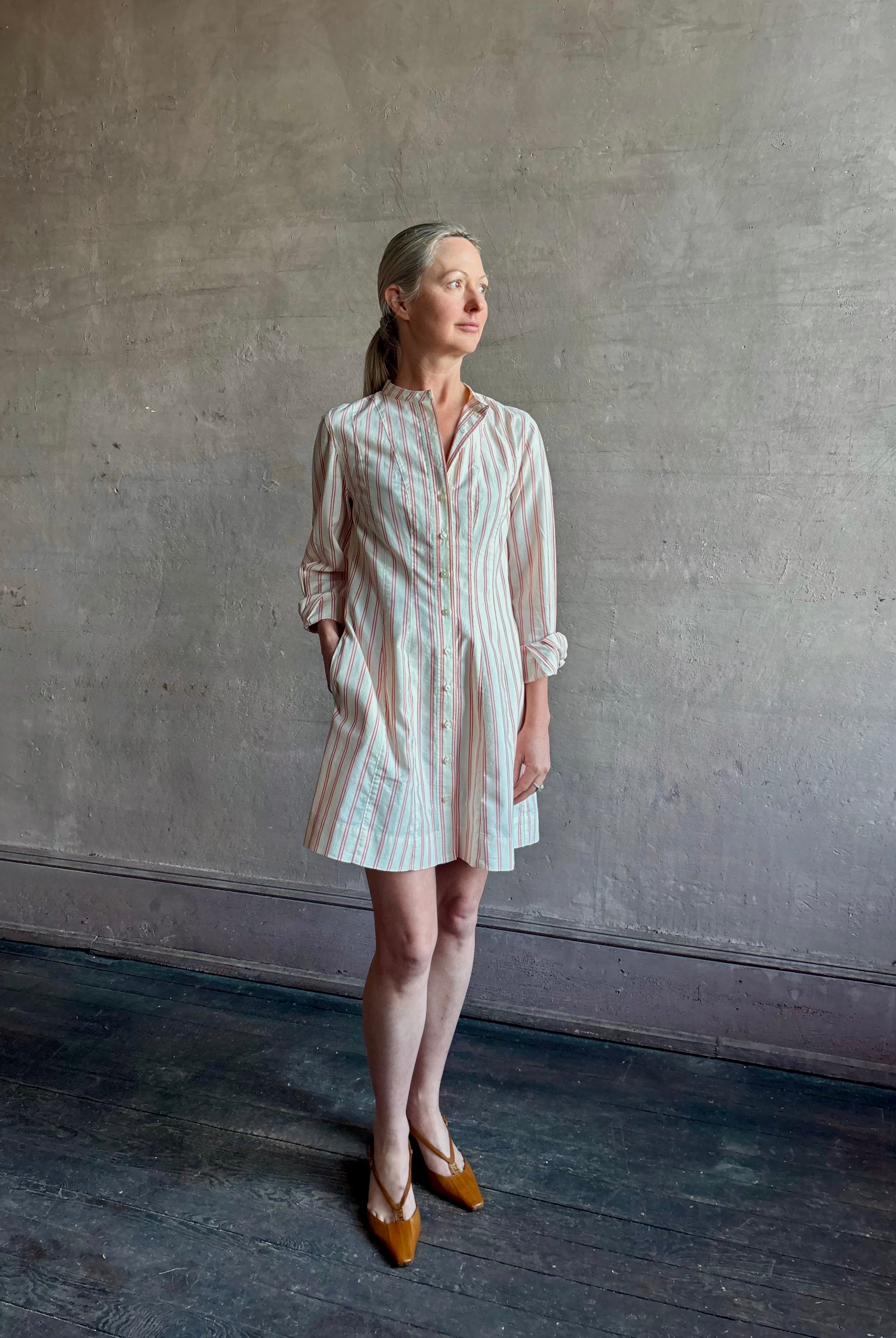 Woman wearing elevated casual wear Trovata Marina cotton shirt Dress in cream and red Stripe with mandarin collar, long sleeves, pockets and expert tailoring