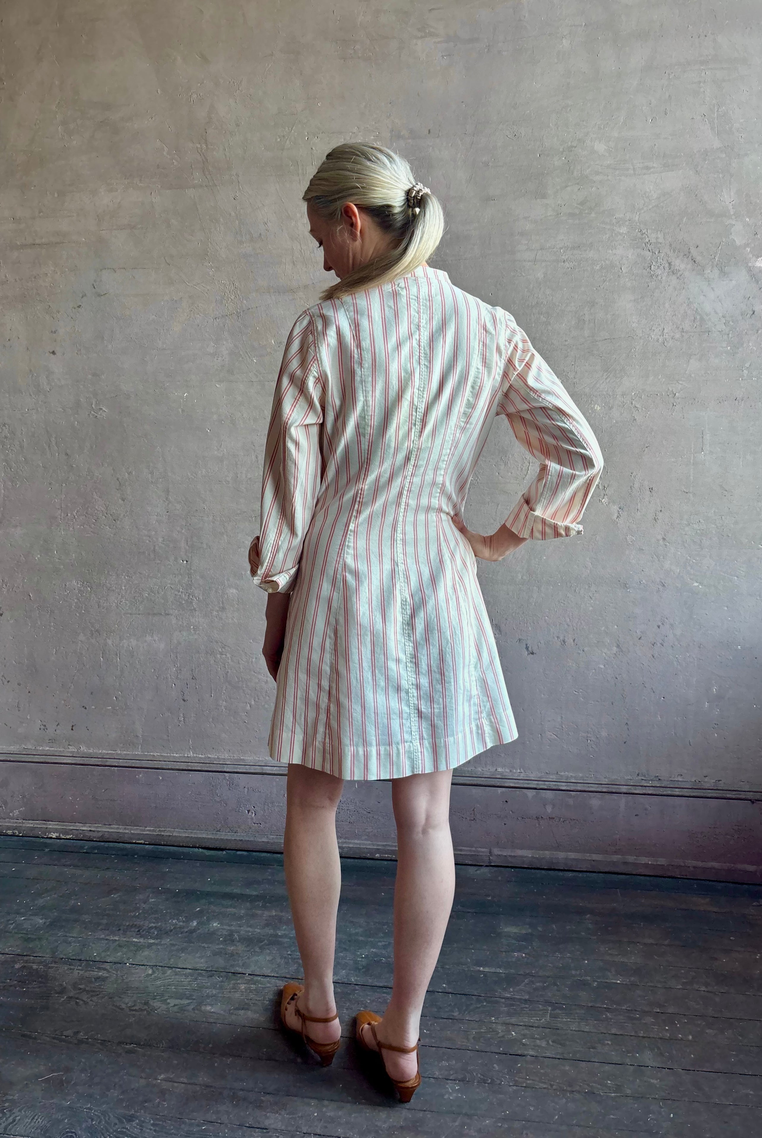 Woman wearing elevated casual wear Trovata Marina cotton shirt Dress in cream and red Stripe with mandarin collar, long sleeves and pockets